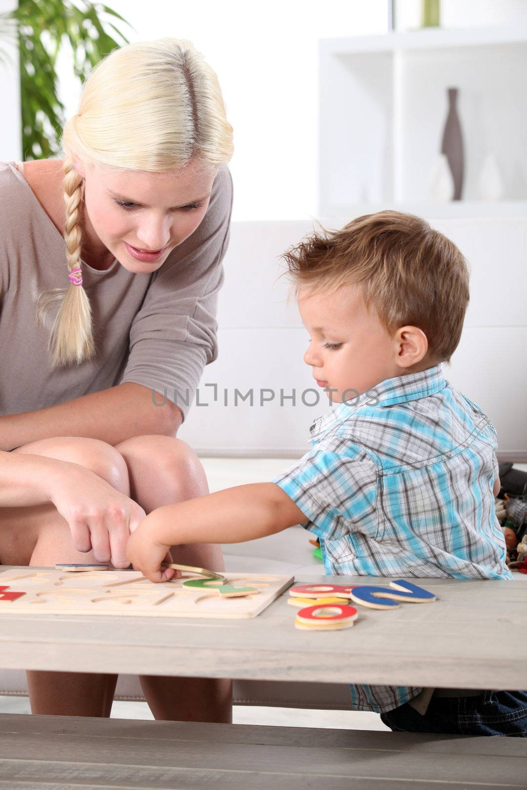 Mother and son doing a jigsaw puzzle by phovoir