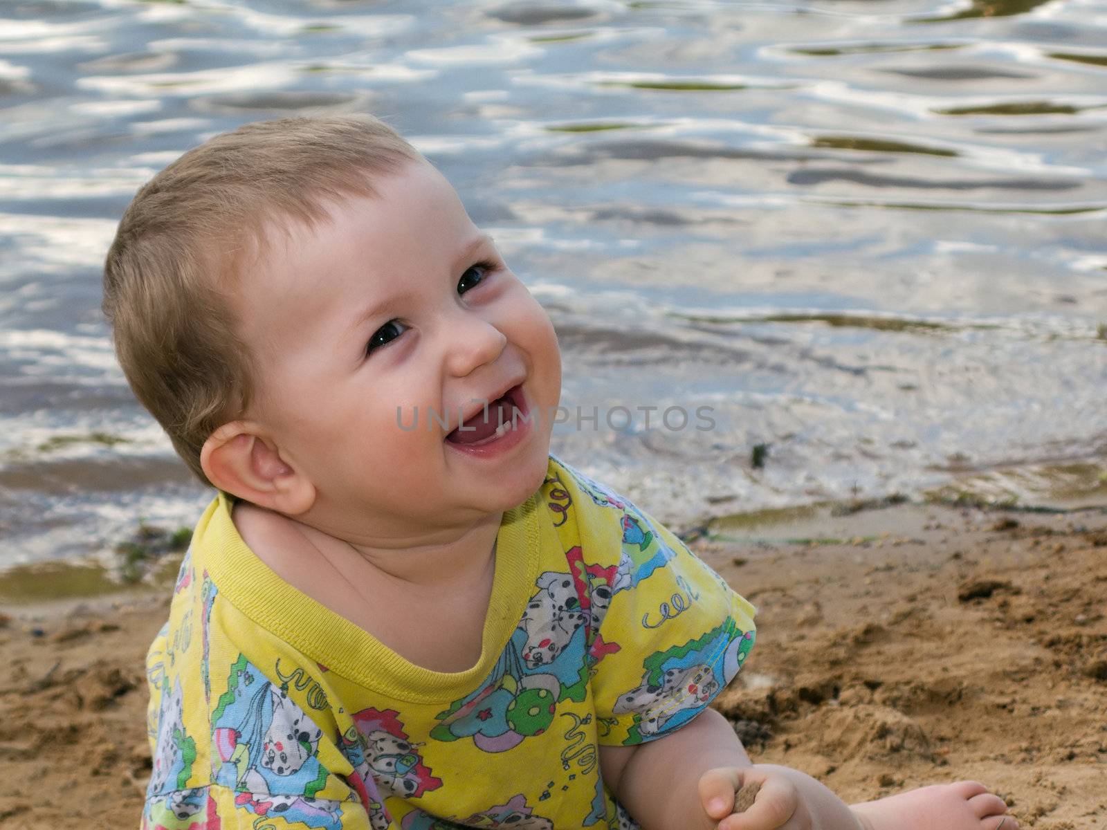 Little child smiling on water beach at summer