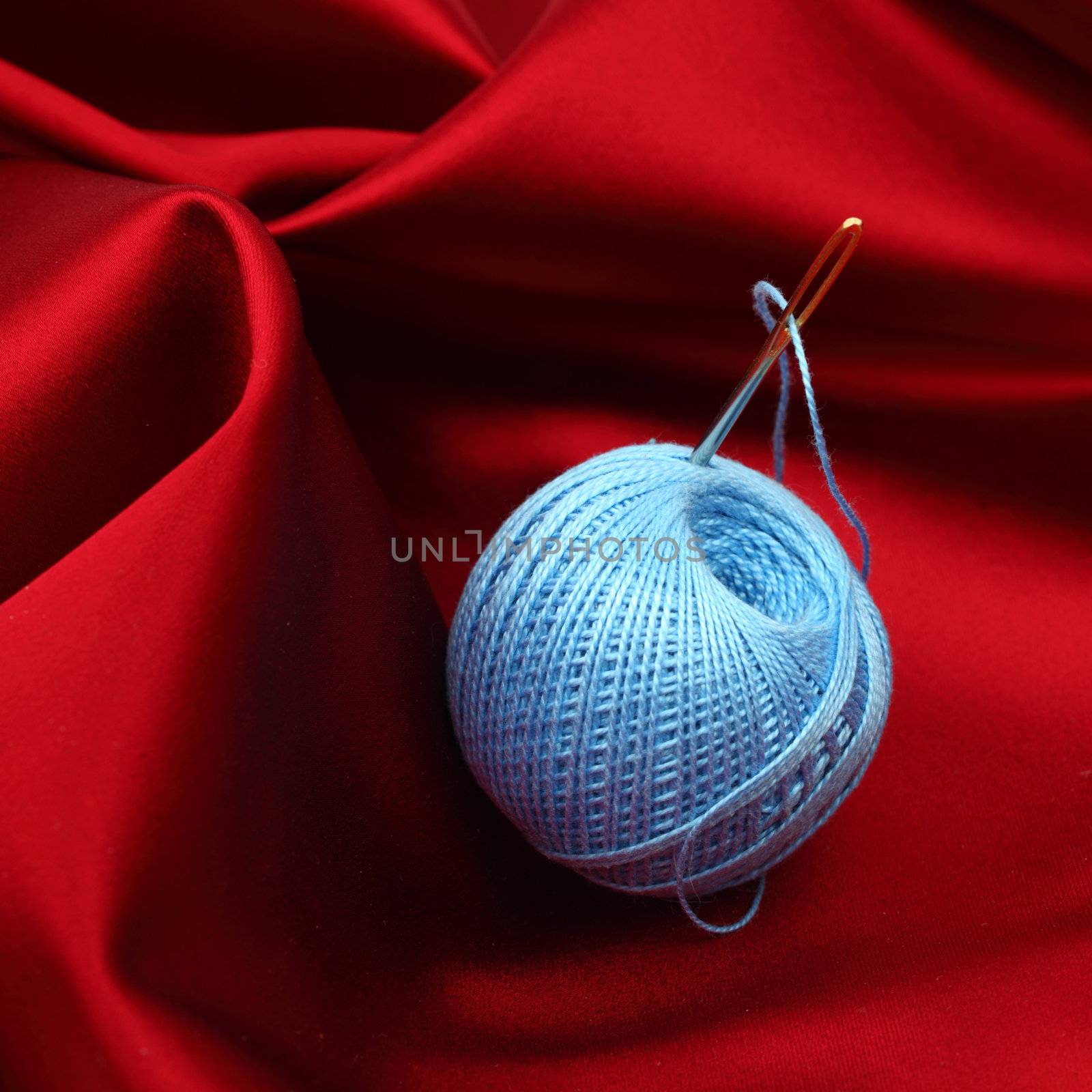 thread on red silk isolated close up