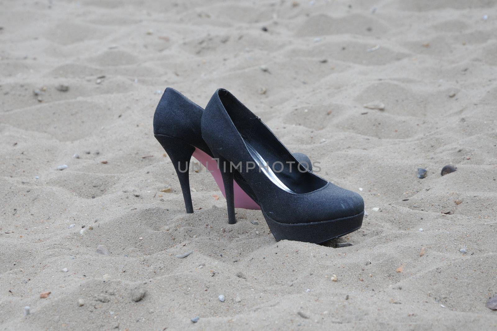 Pair of female shoes on sand