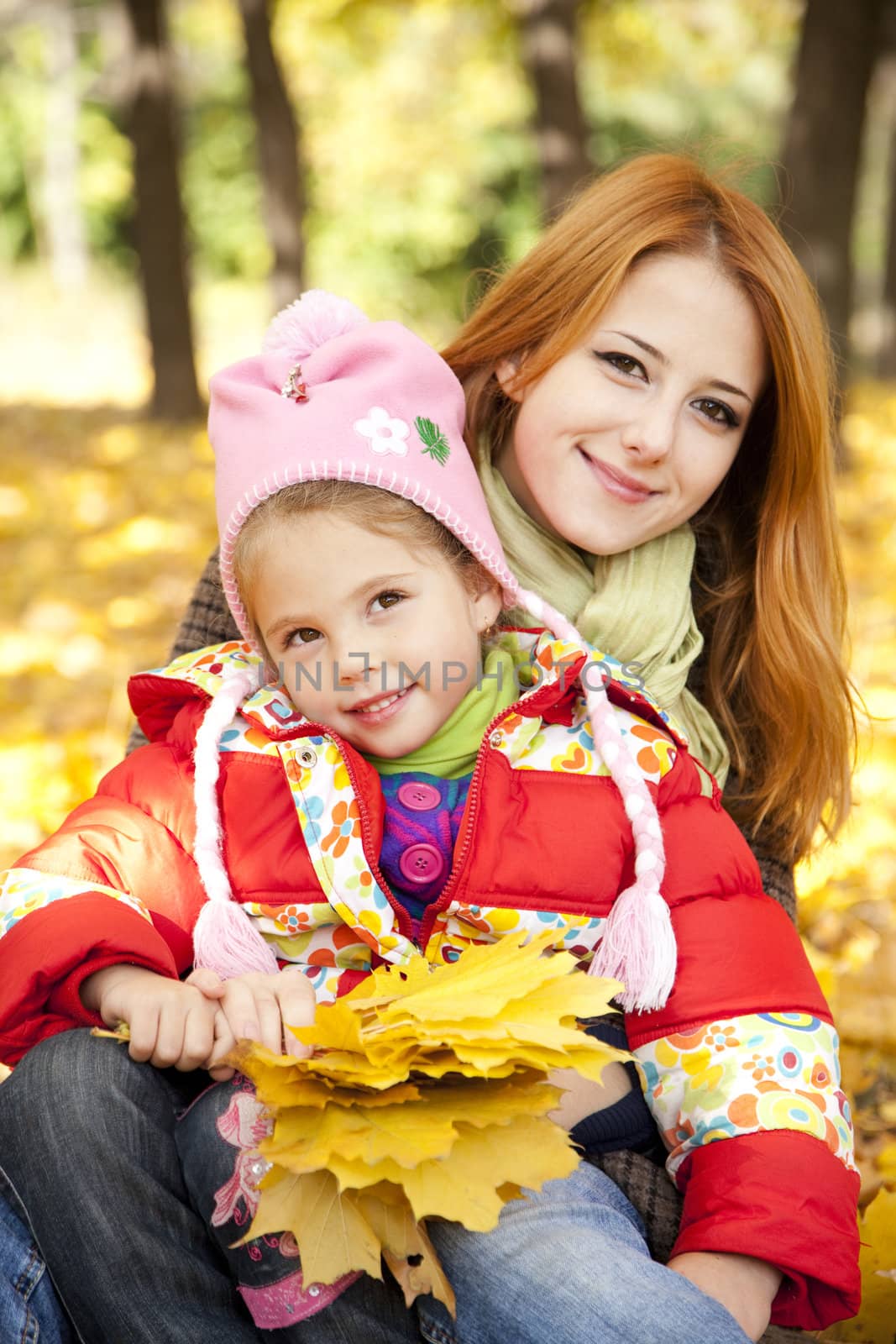 Mother and daughter in autumn yellow park by masson