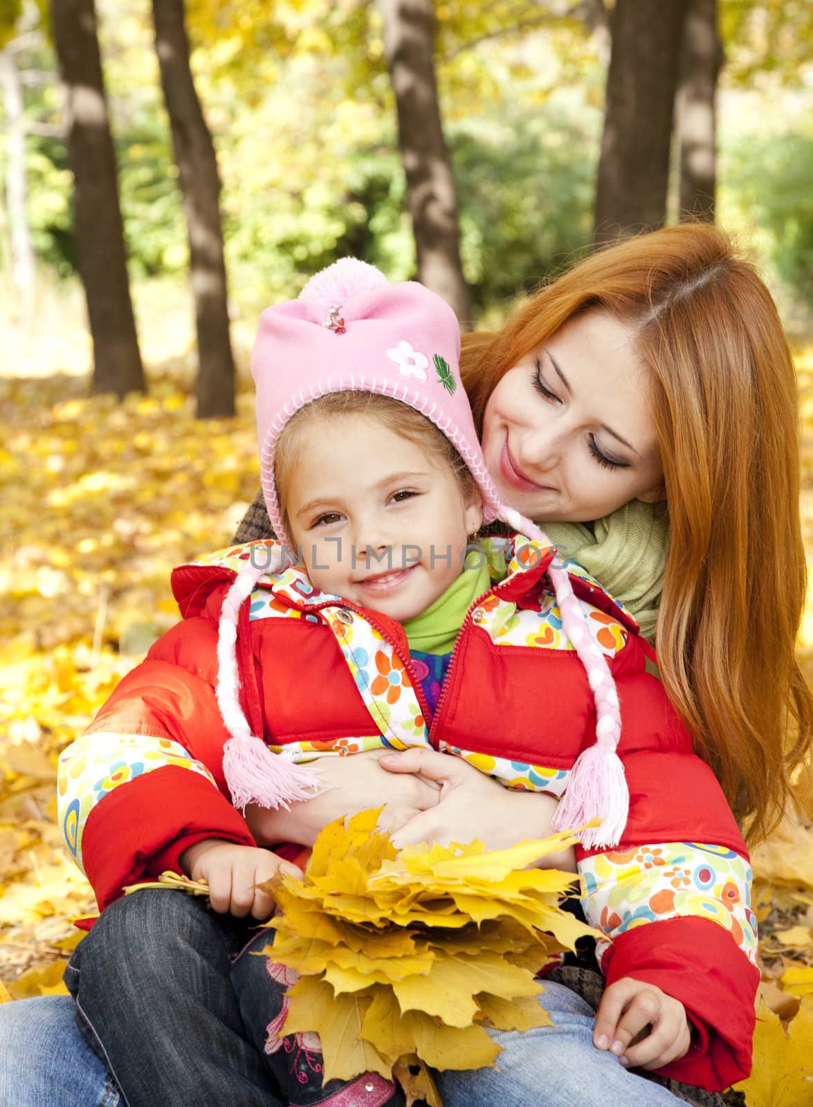 Mother and daughter in autumn yellow park by masson