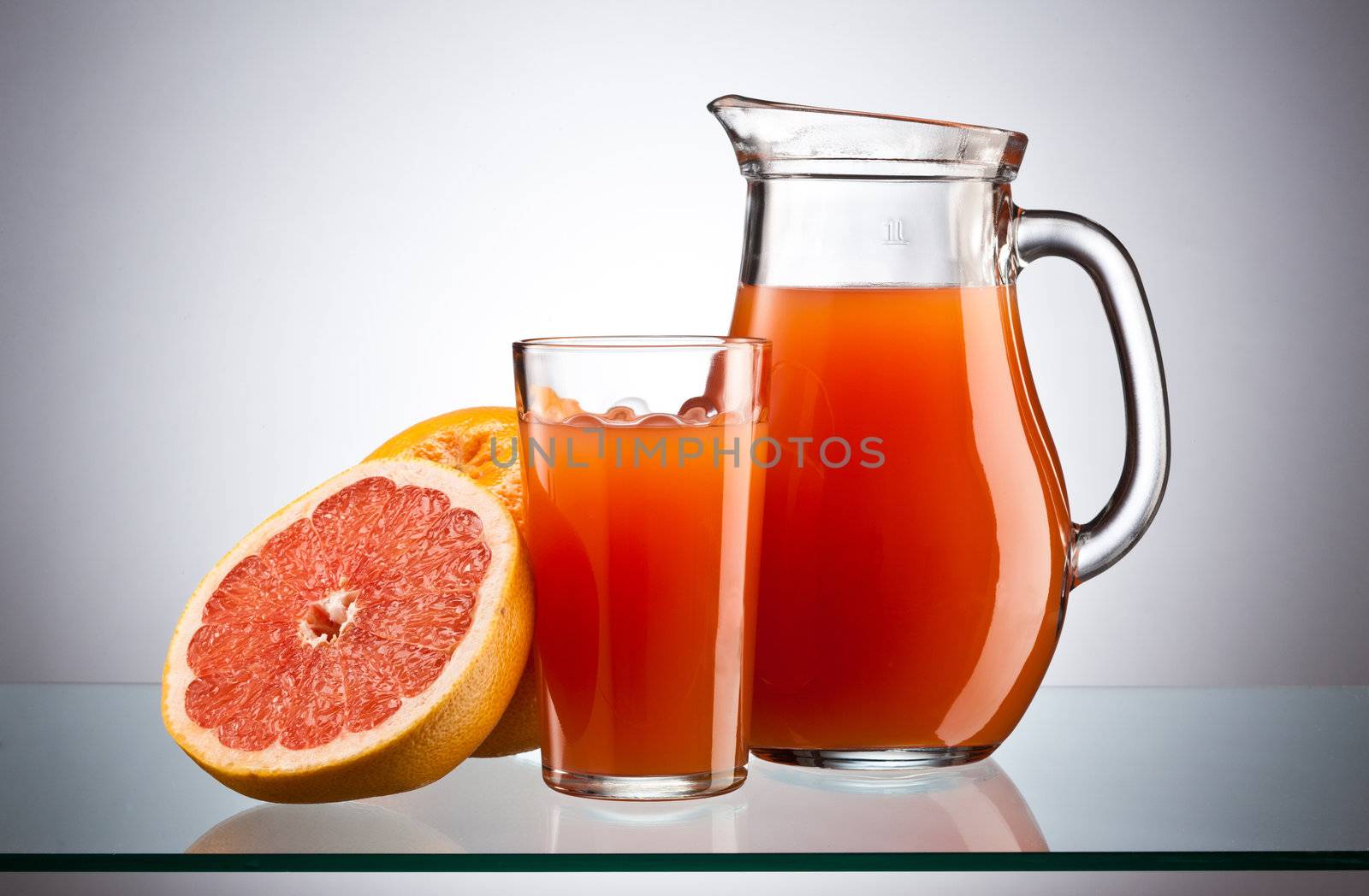 fresh grapefruit juice in the glass and jar over white