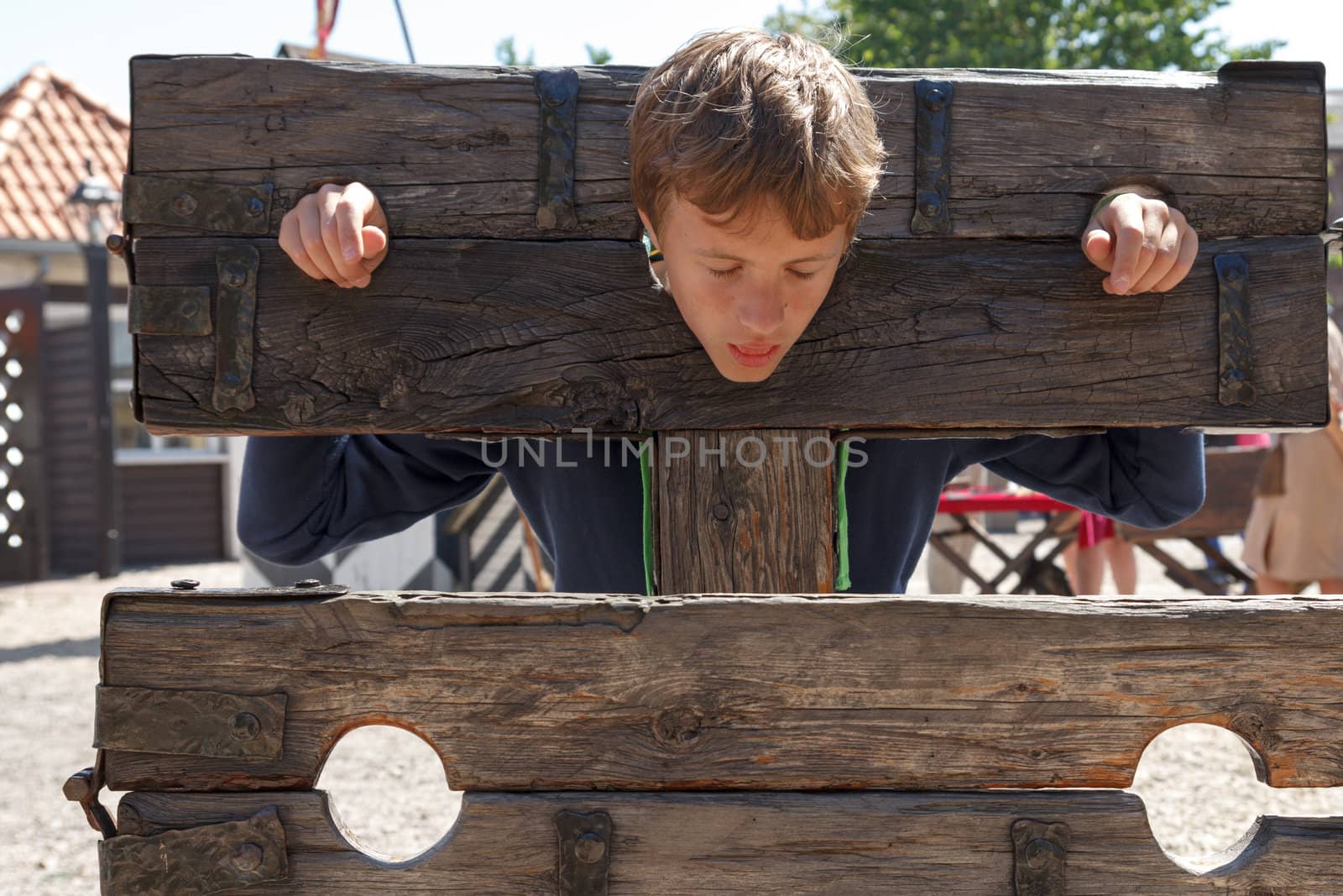 a boy trapped in a medieval torture device