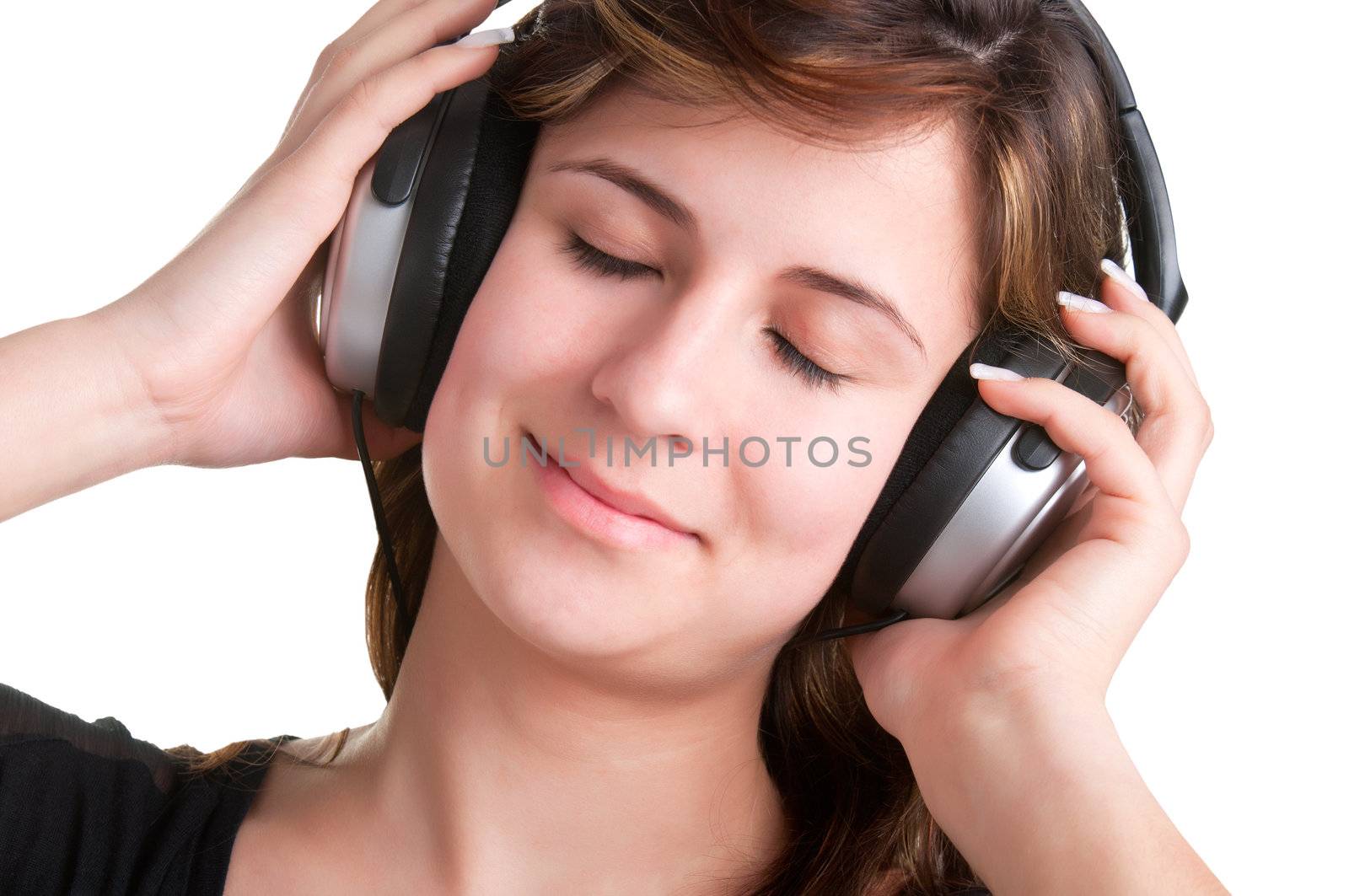 Young woman listening to music through her headphones, with her eyes closed, isolated in a white background
