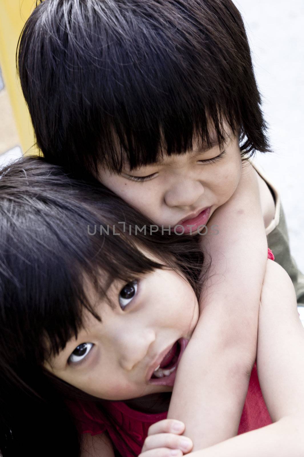Caring Asian Sister carrying injured little brother