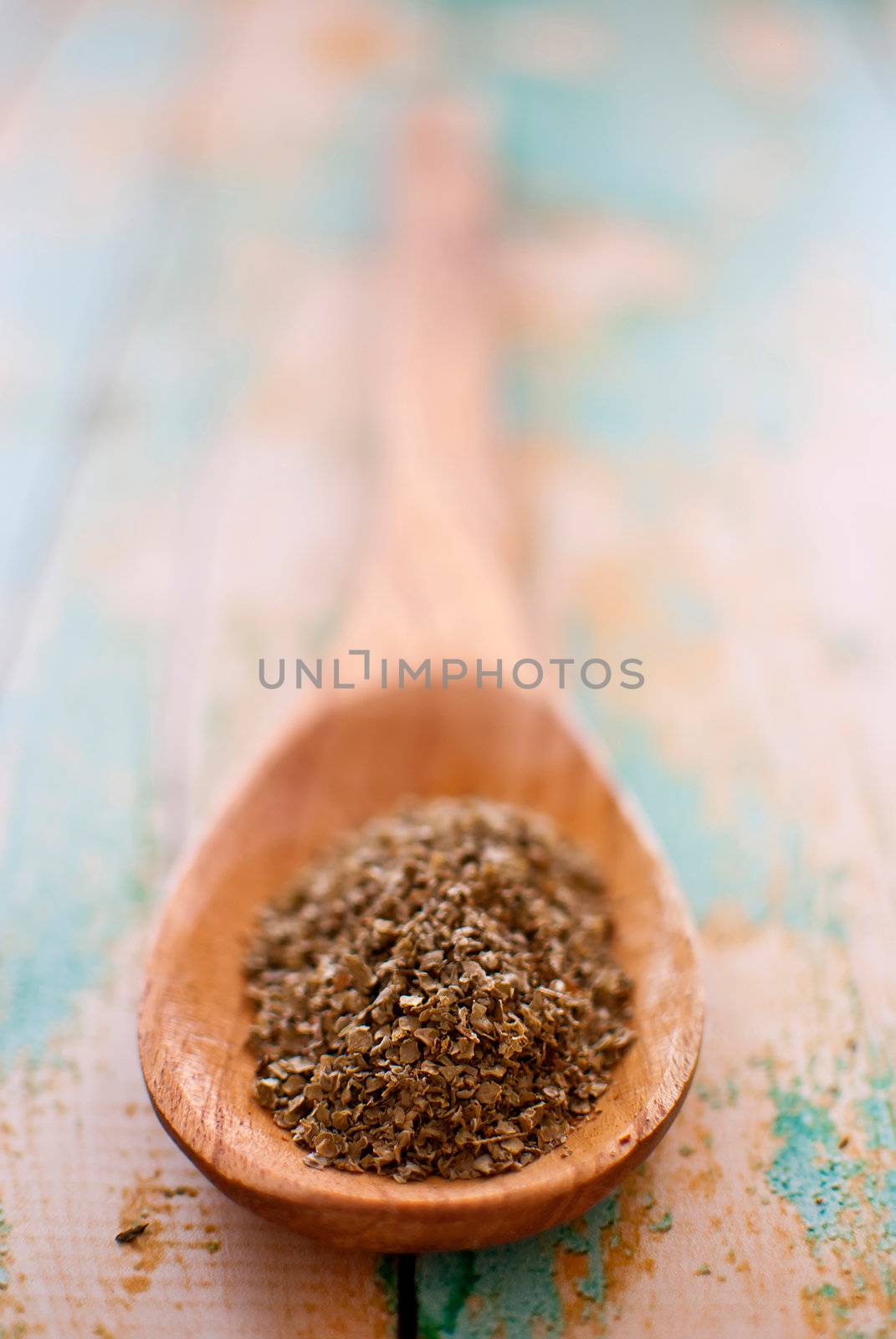 marjoram spice in wooden spoon over wood background - selective focus