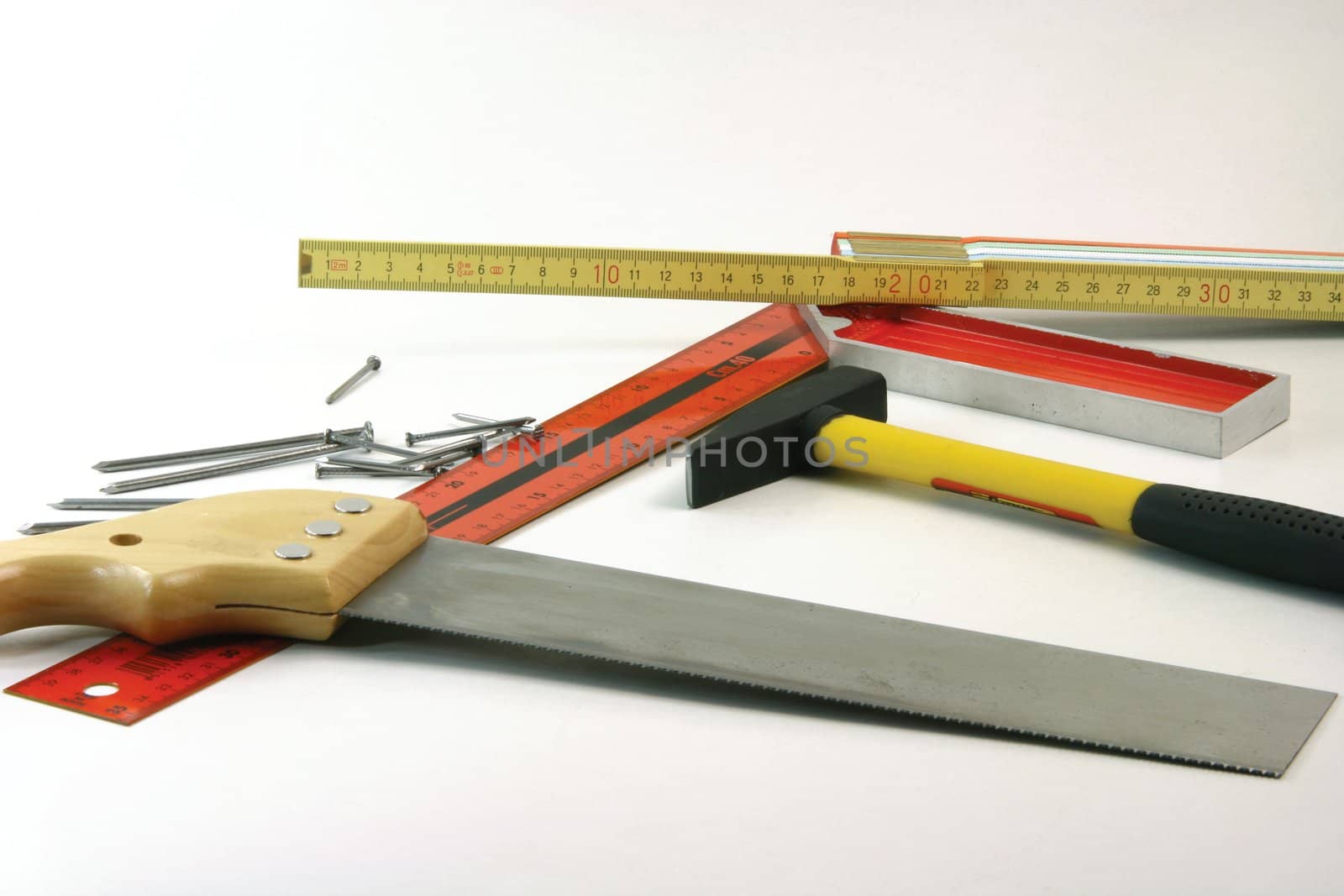 construction concepts carpenter tools meter hammer, nails, angle meter, hand saw on white