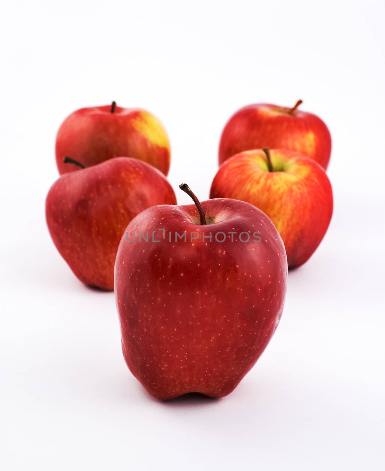 Five apples on white background with shallow depth of field