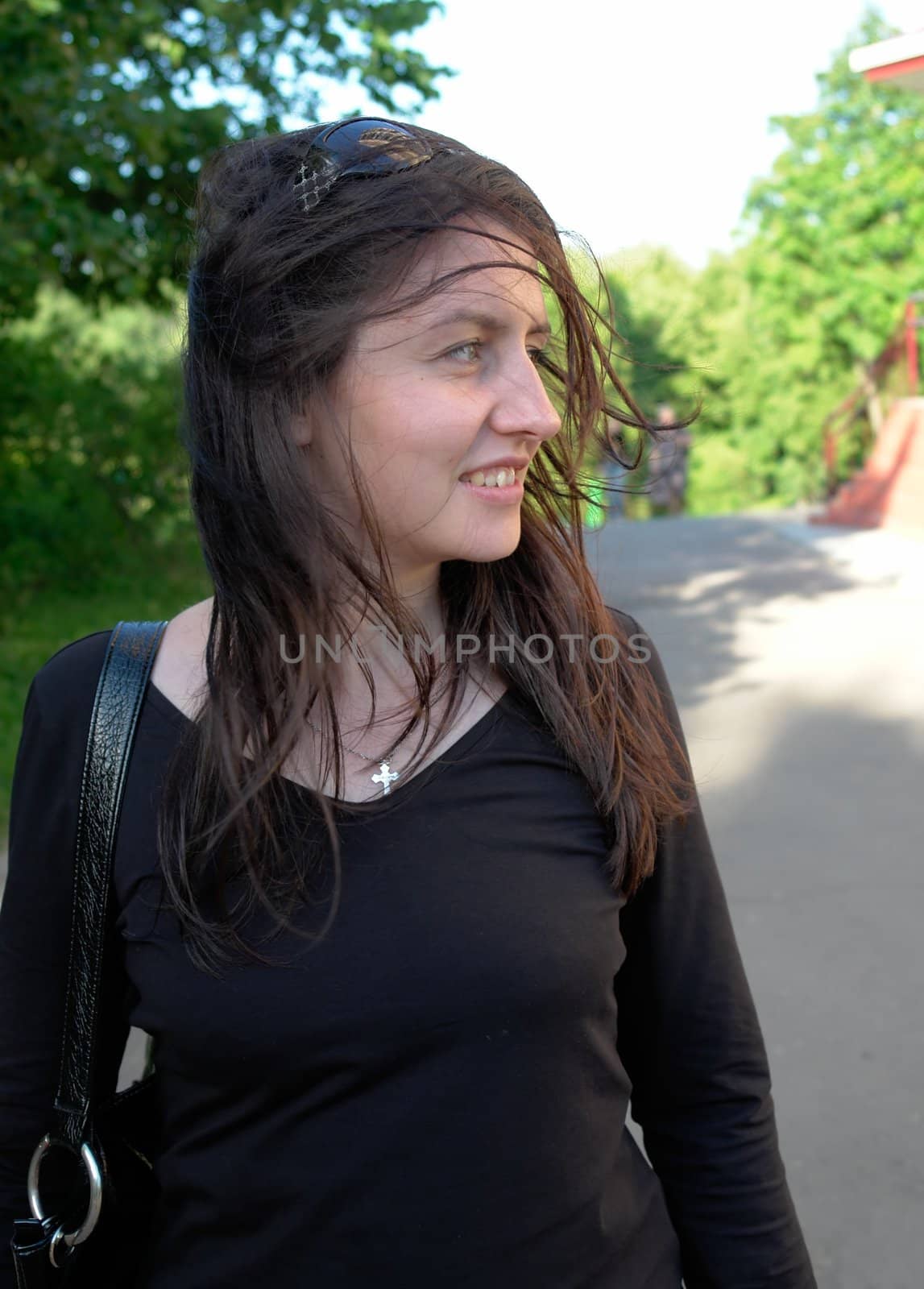 The smiling young woman  in city street.