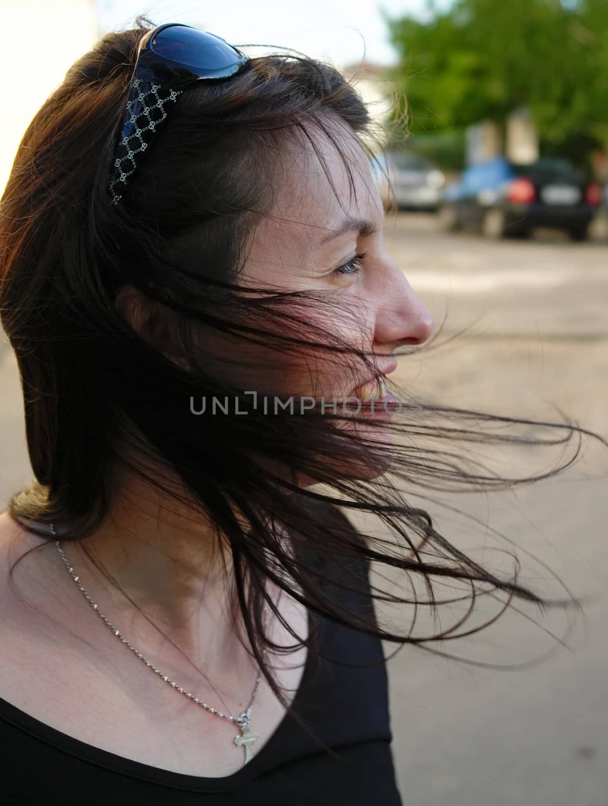 Wind. The young beautiful woman in park.