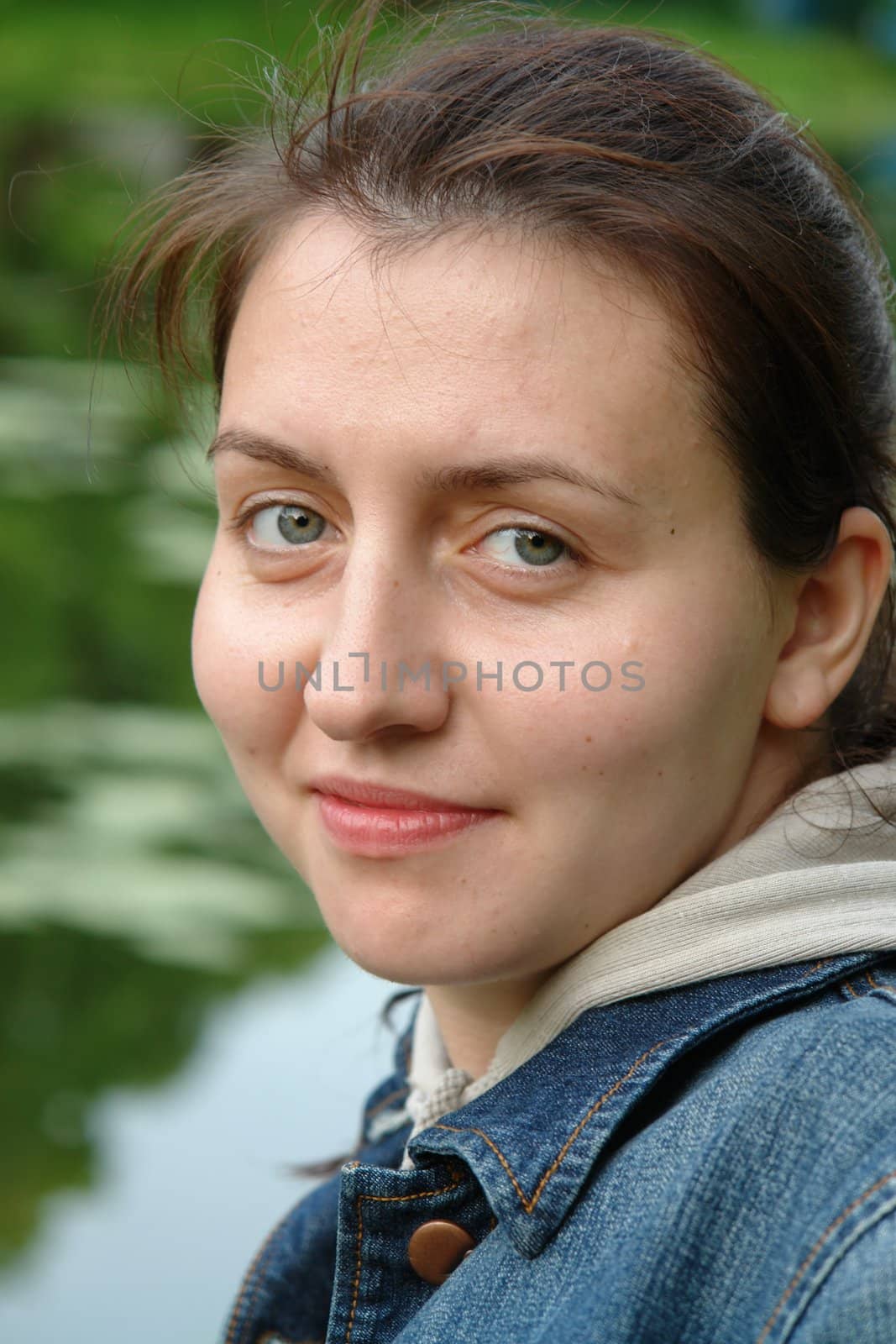 young beautiful woman close up against the river