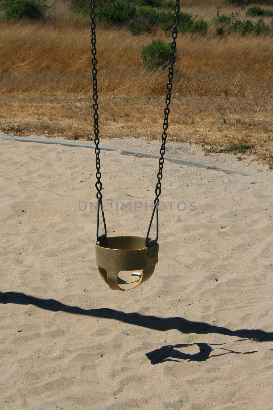 Close up of swings in a playground.
