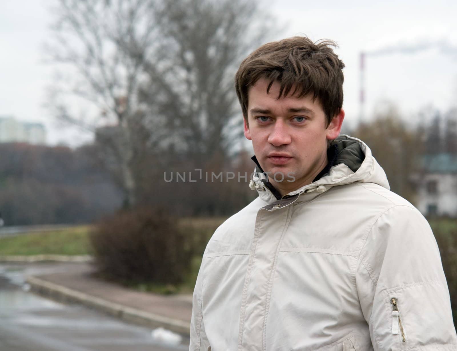Cloudy day. The young man in city street.