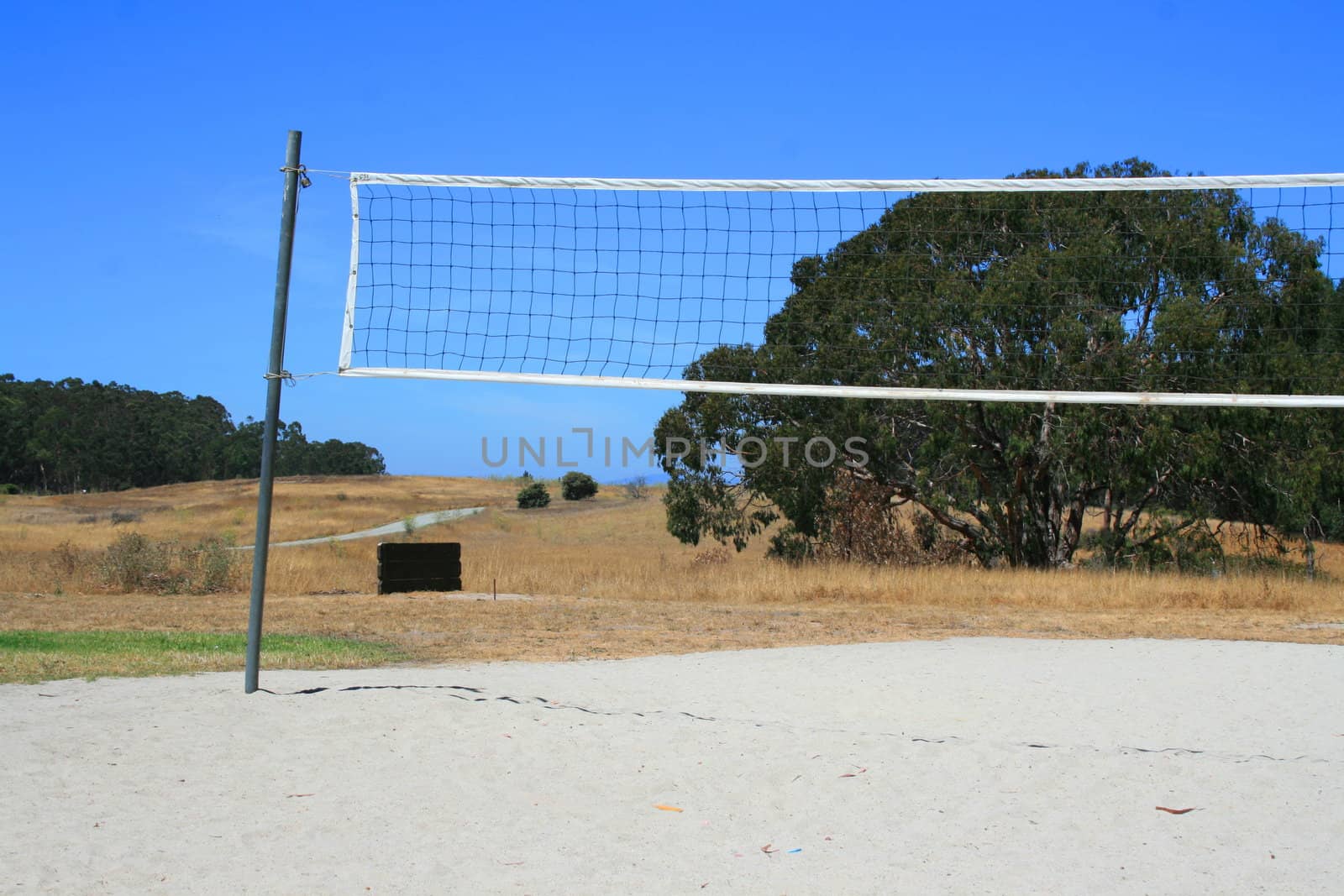 Beach volleyball net over bright blue sky.
