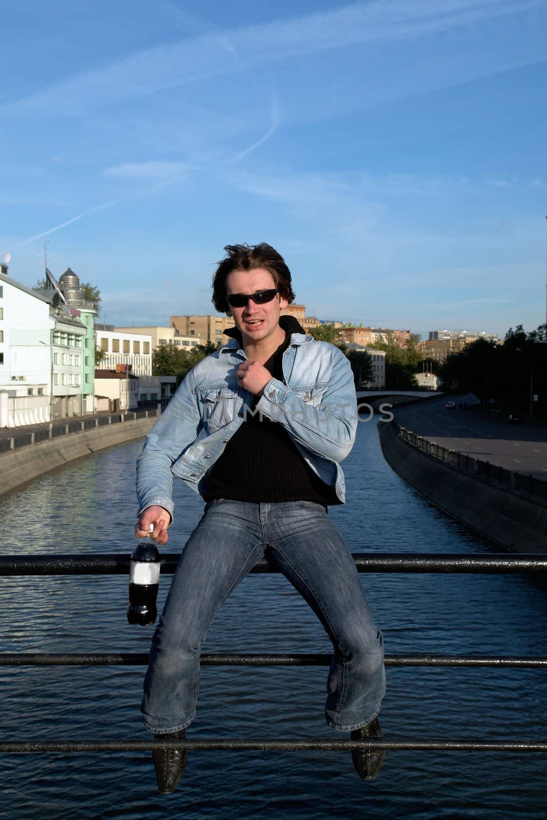 Cool dude with a bottle against the river