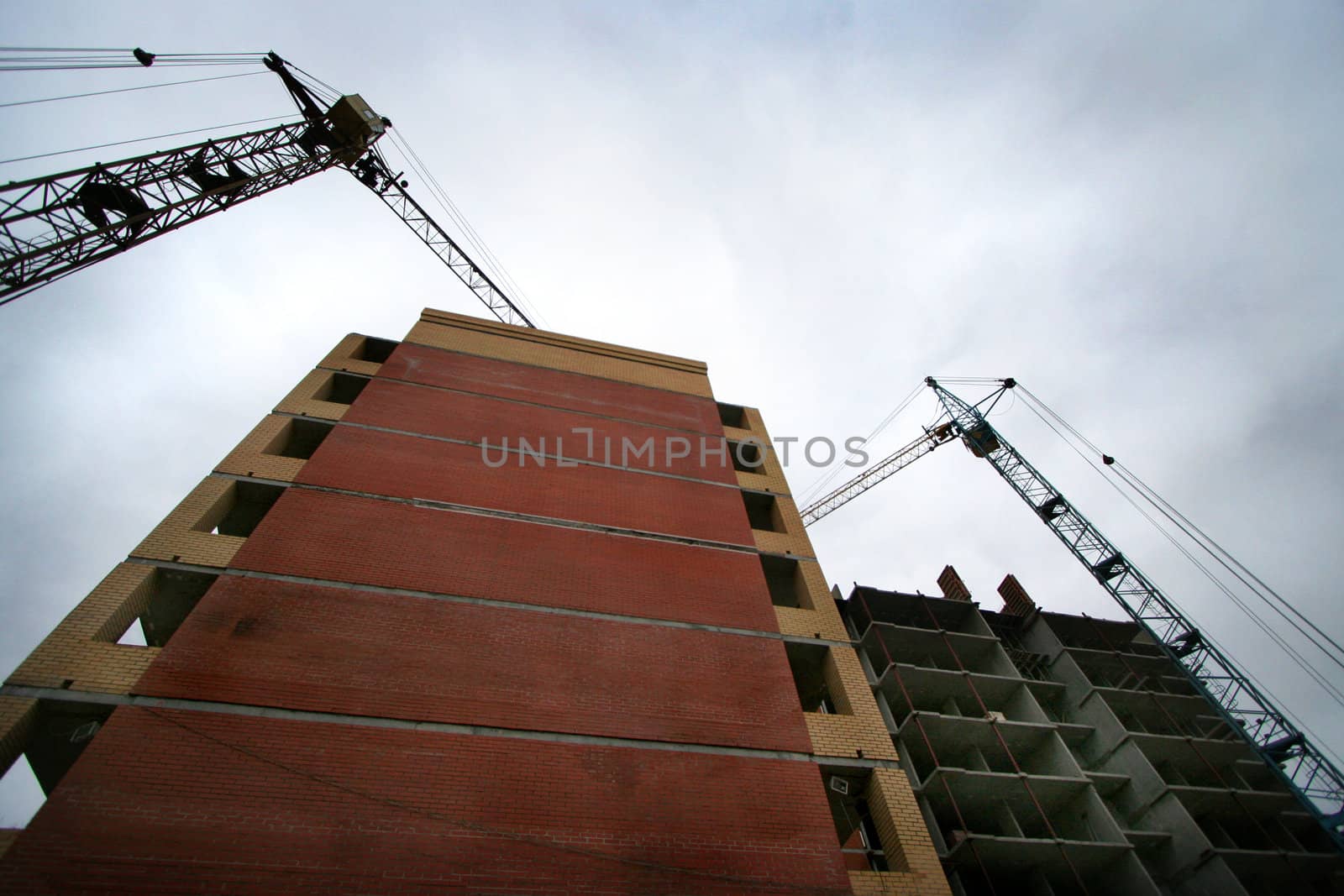 Elevating cranes build the brick house