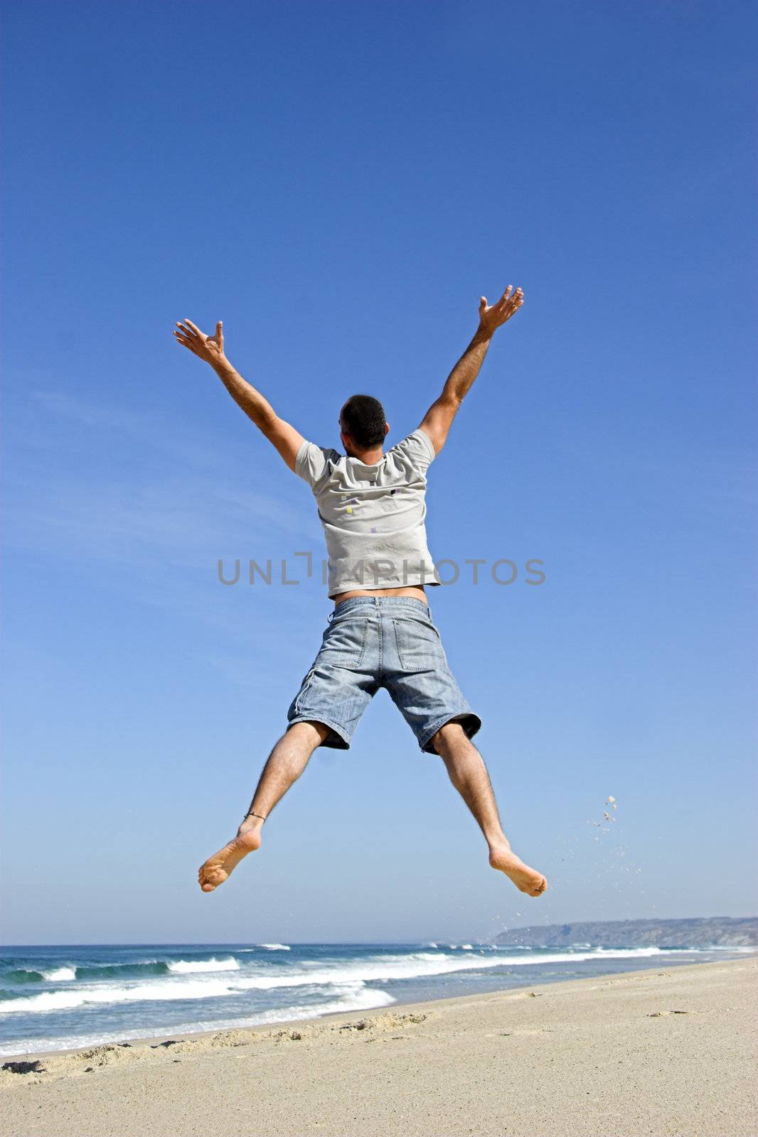 Man jumping on the beach and having fun