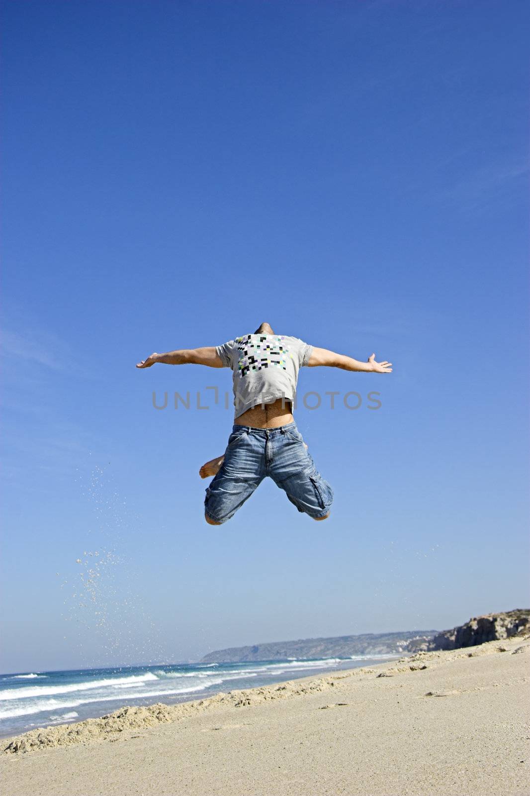 Man jumping on the beach and having fun