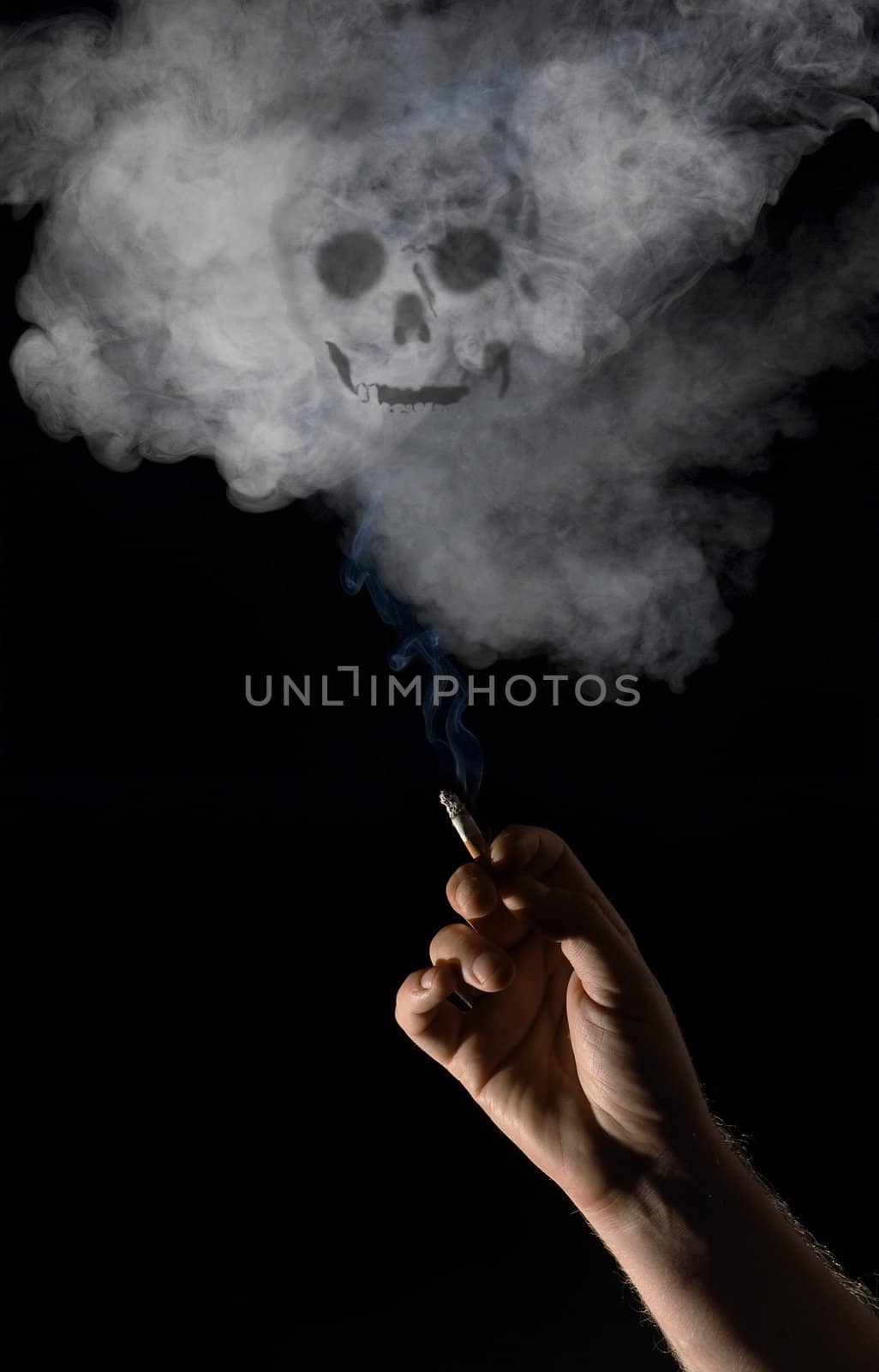 Hand holding lit cigarette with skull appearing in smoke! 