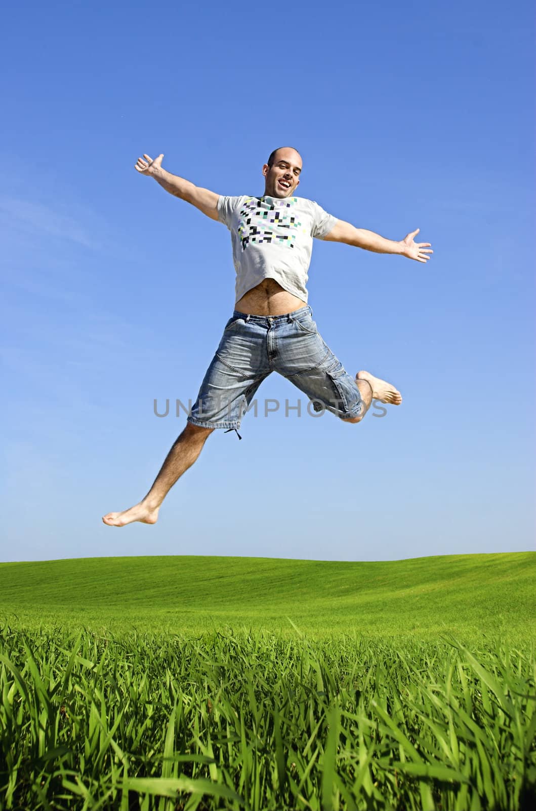 Man making a big jump on a beautiful green meadow