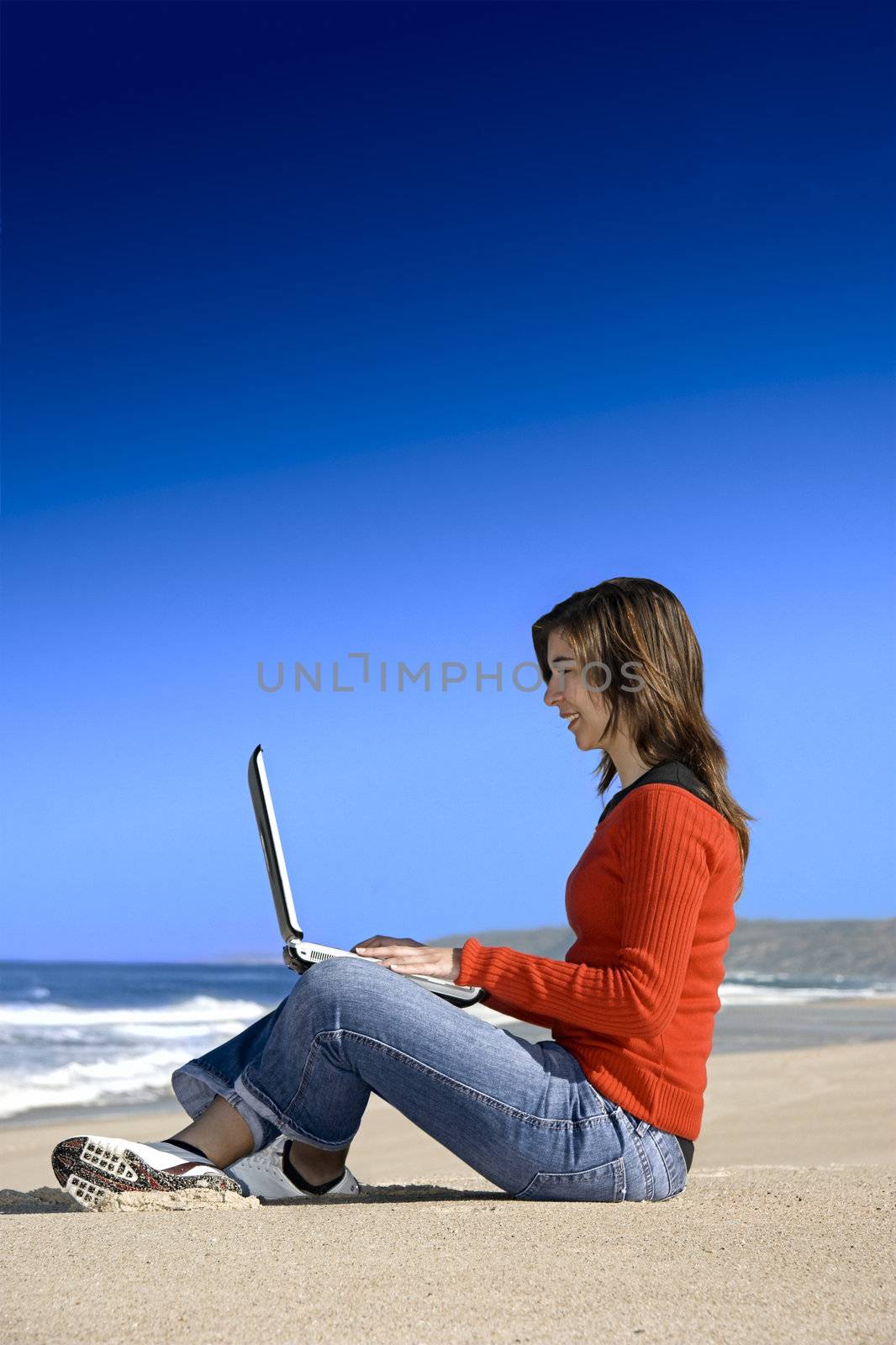 Woman working with a laptop on the beach