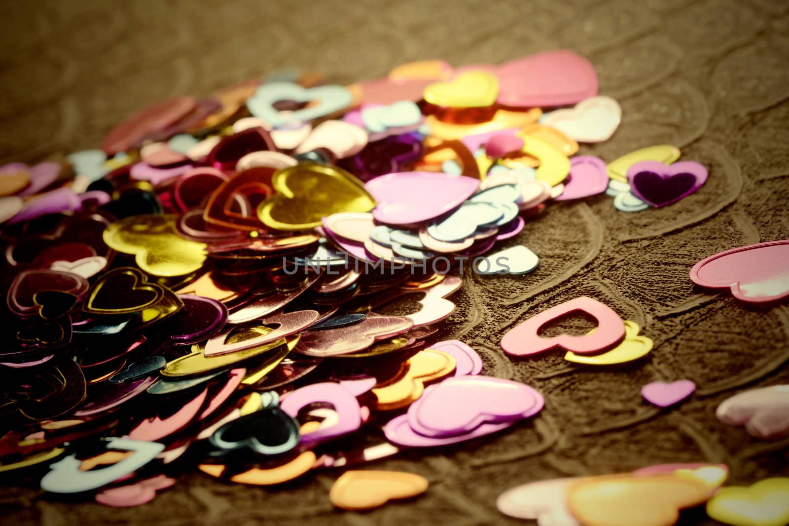 metallic confetti hearts on brown background