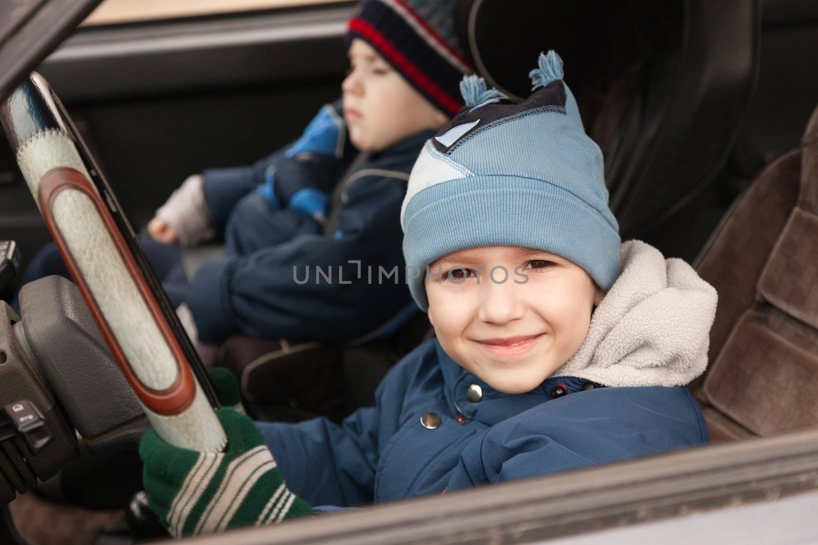 Little smiling child boy driving sport car vehicle