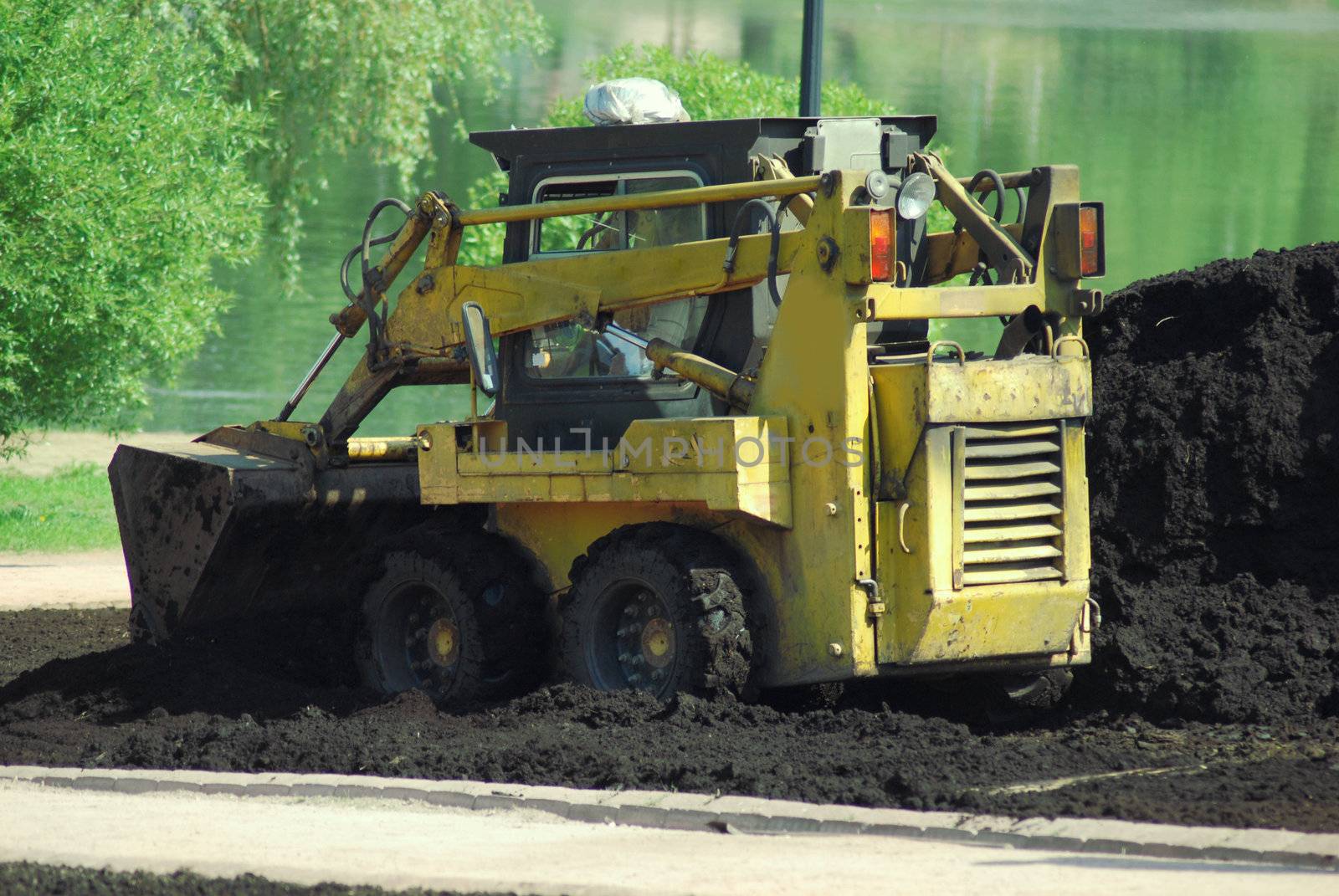 Mini excavator-grab working in city park  at the spring by svtrotof