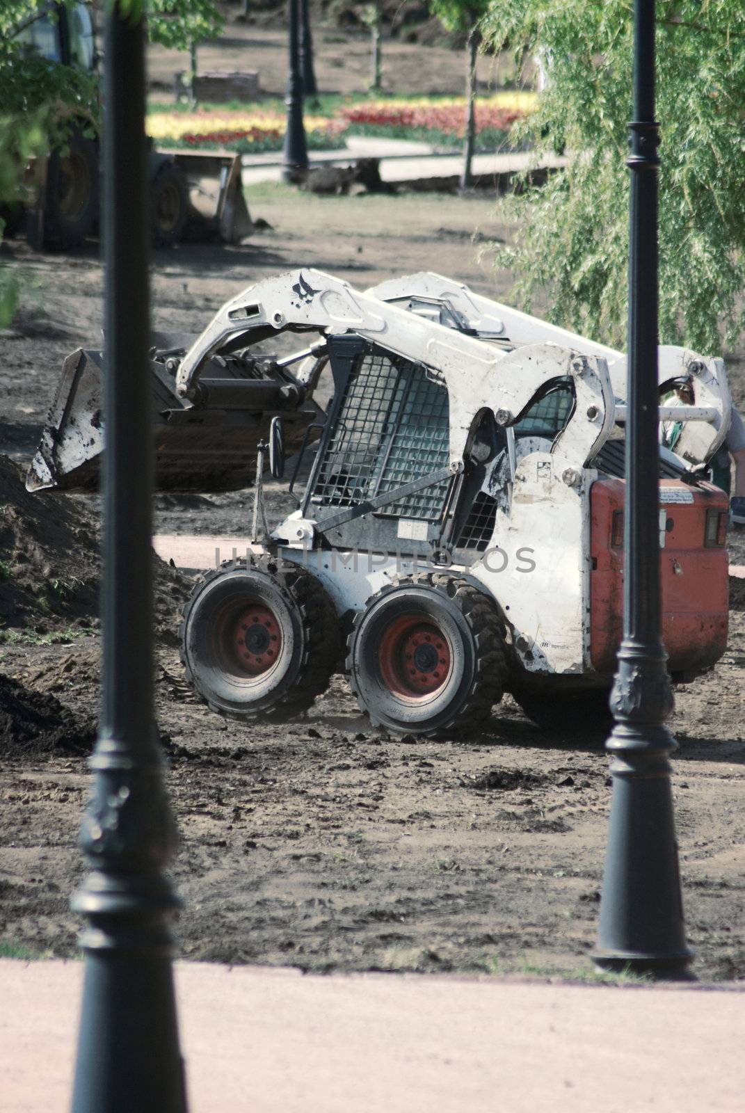 mini wheel excavator working in city park at the spring by svtrotof