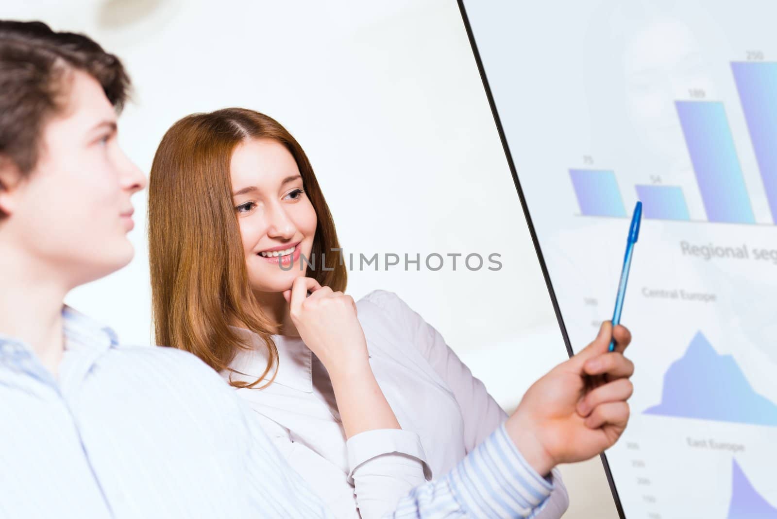 attractive business woman with a colleague discussing charts and graphs on the screen, Collaboration