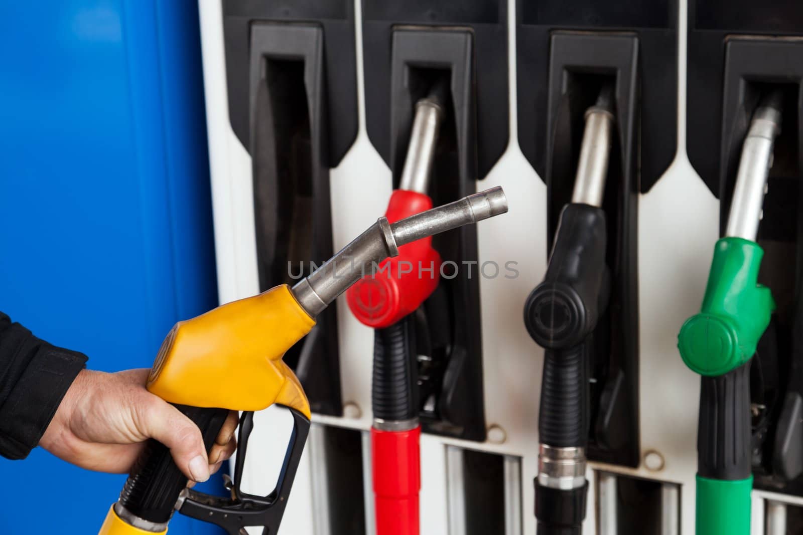 Human hand holding gasoline station gas fuel pump
