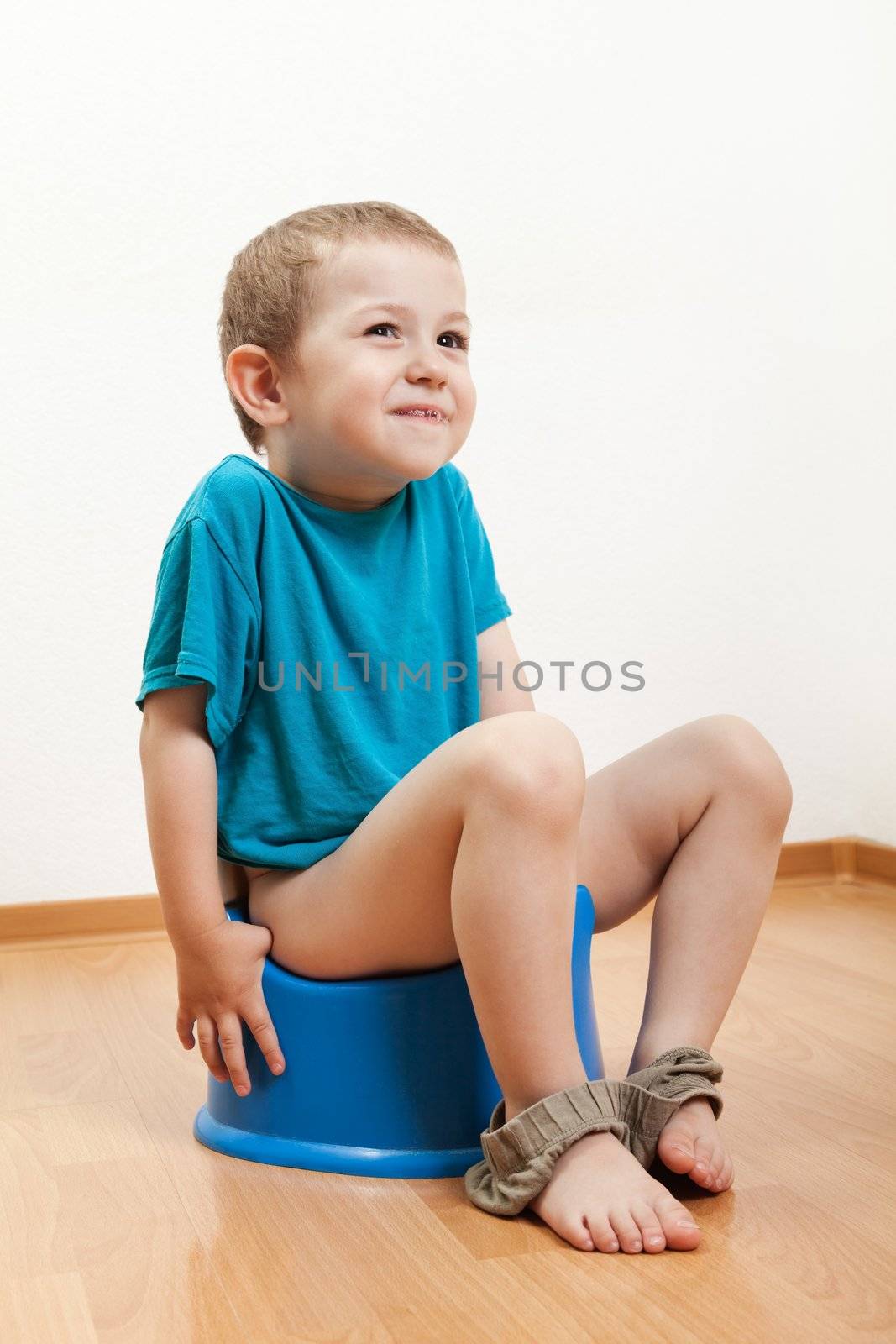 Little smiling child boy urinating toilet potty pan