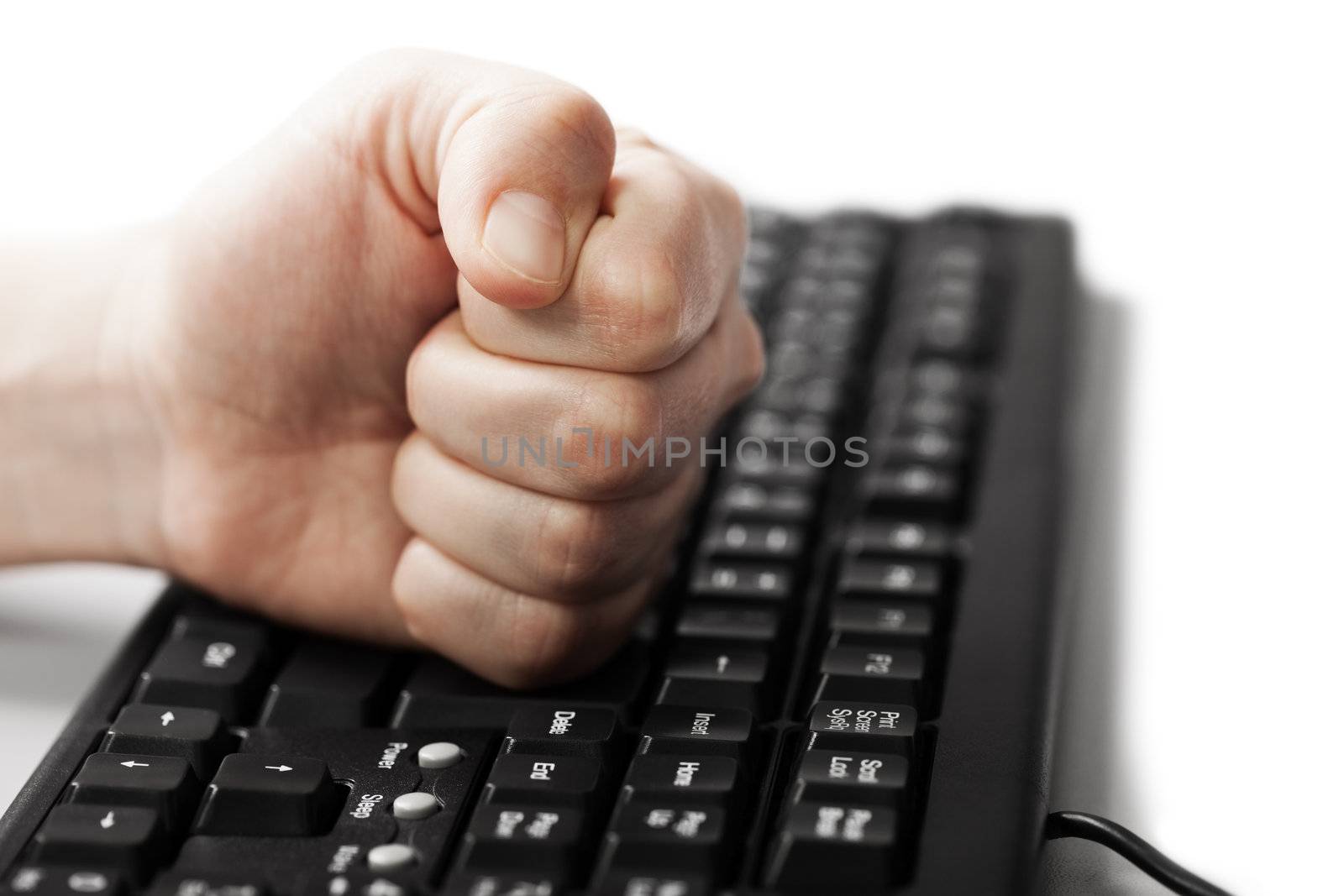 Angry business man hand fist on pc computer keyboard