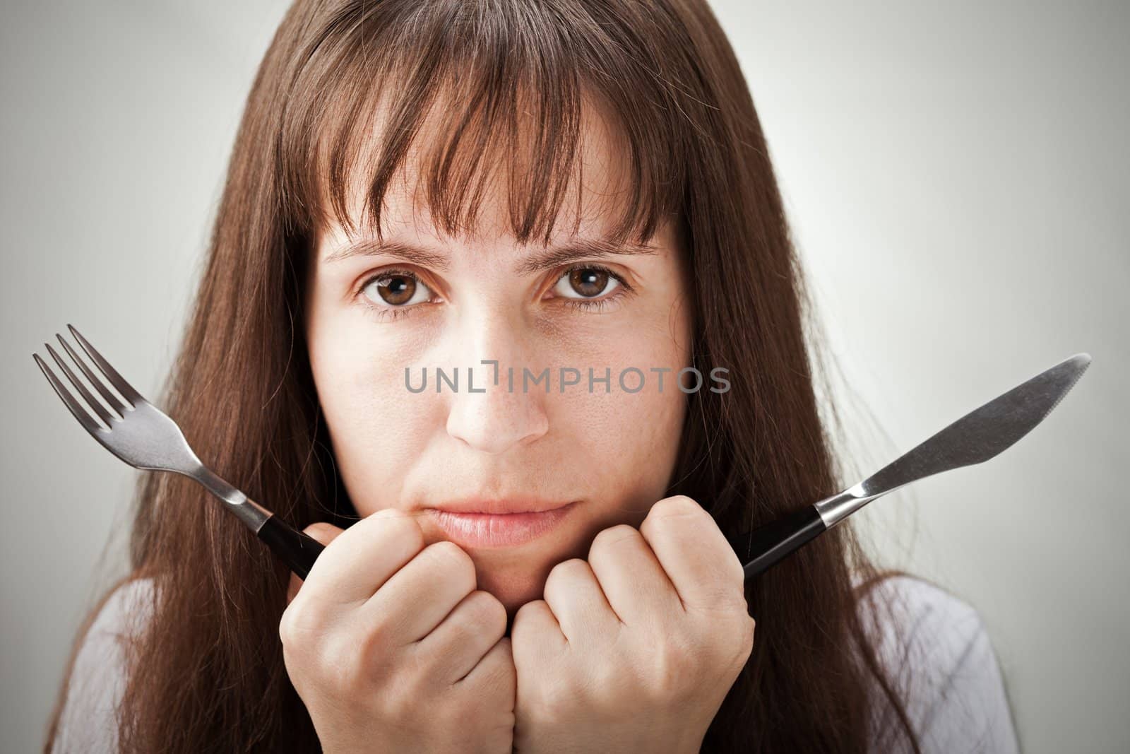 Hungry woman hand holding fork and knife