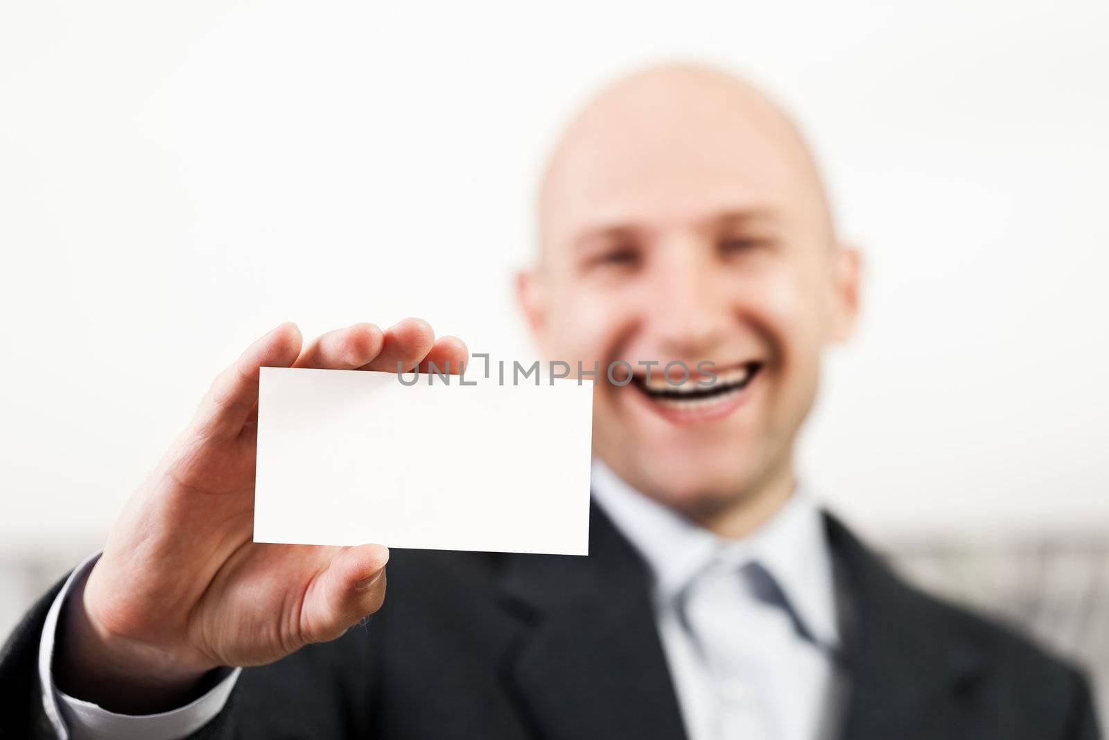 Smiling bald man hand holding blank white business card
