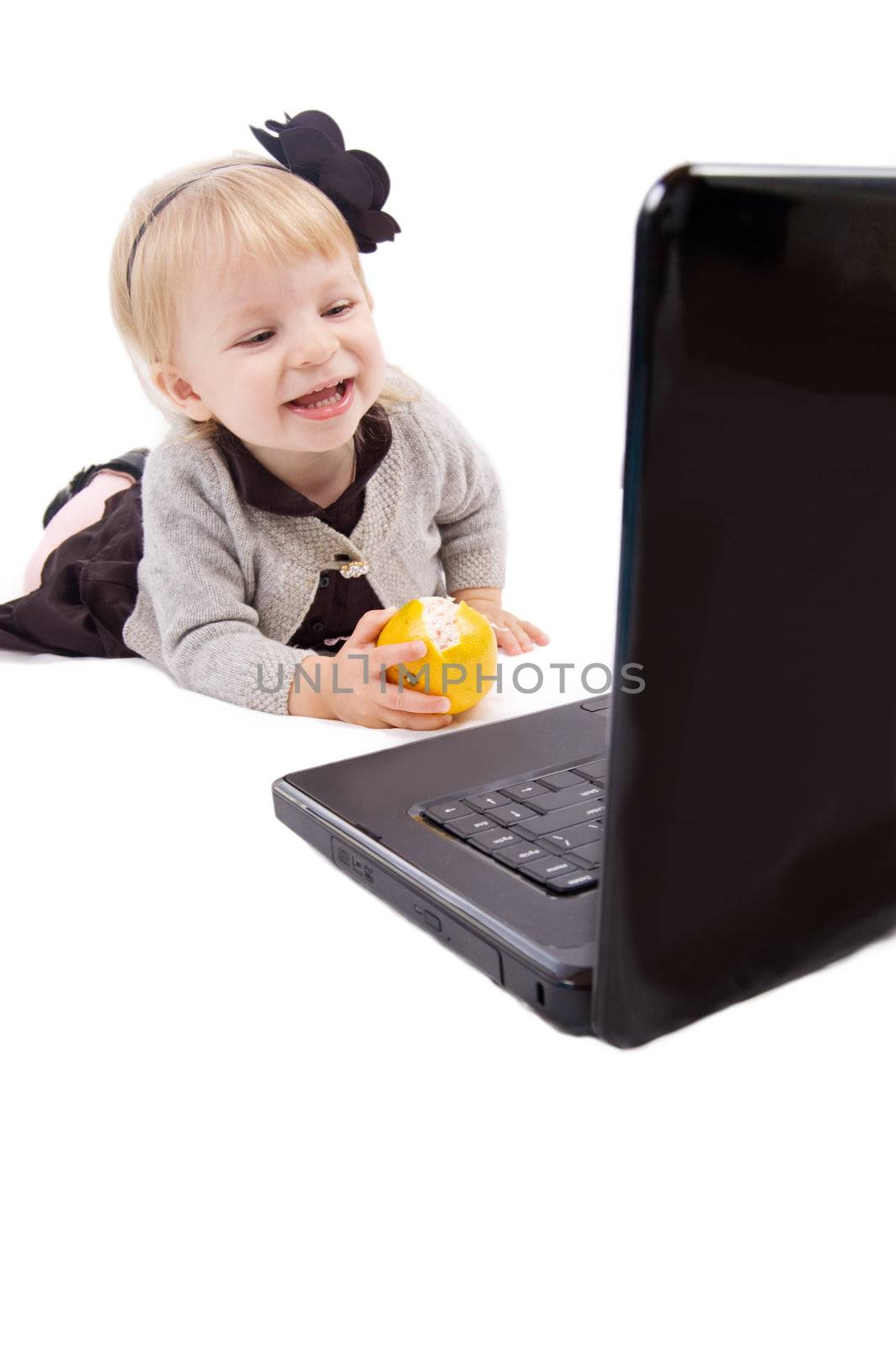 Baby girl playing with laptop over white