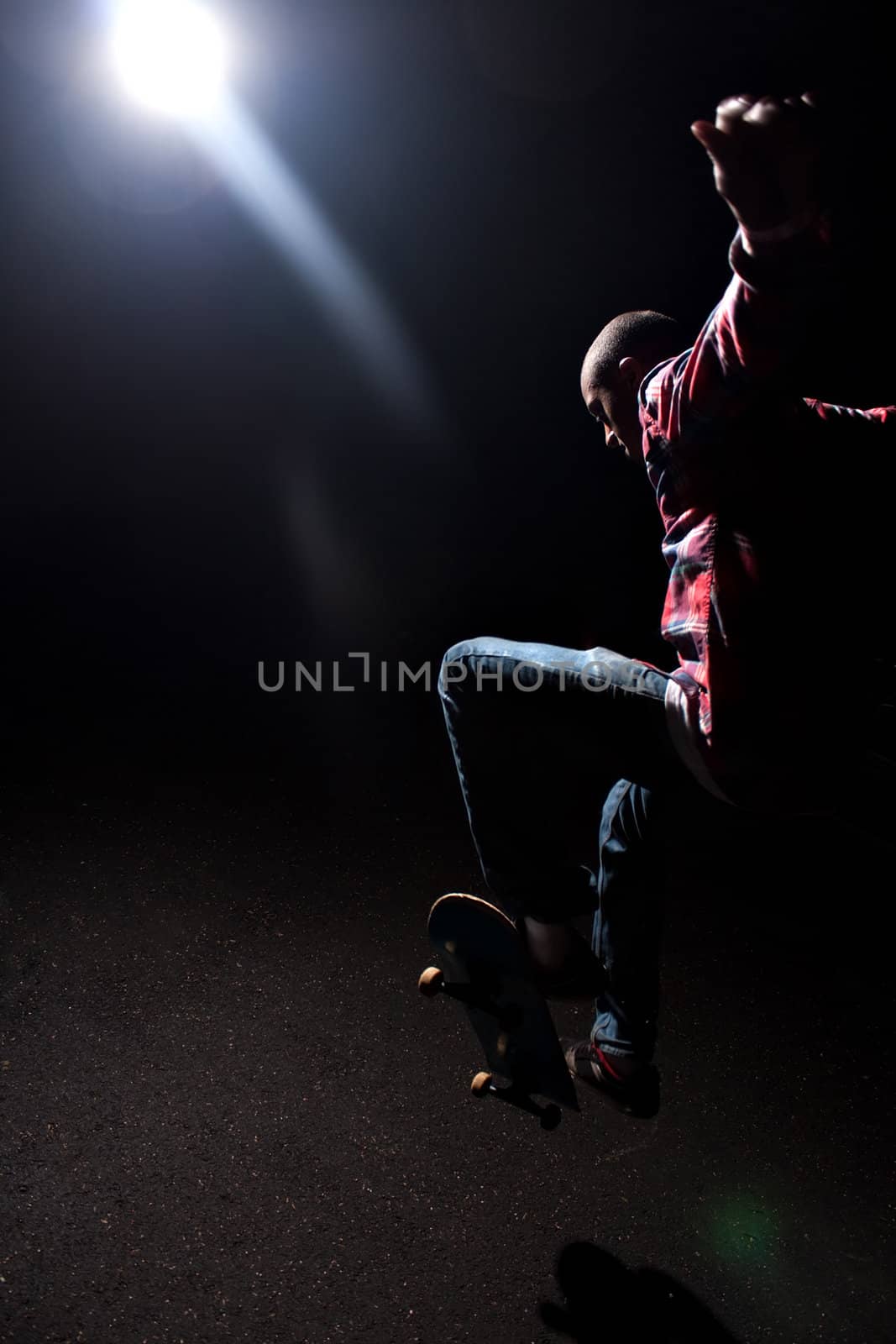 Skateboarder Jumping Under Dramatic Lighting by graficallyminded