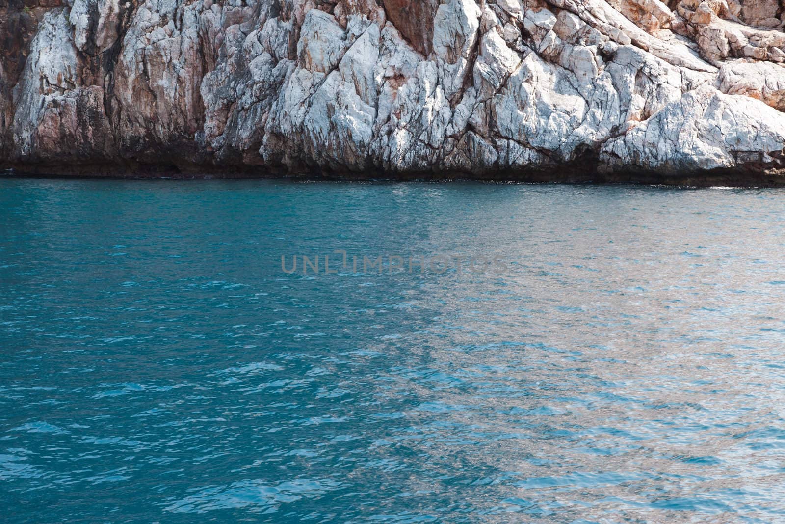 Summer vacations - blue sea water at rocky mountain beach bay