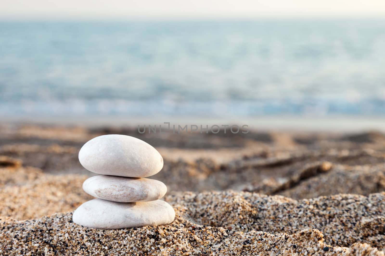 Stack or pile of balancing stones on sea beach by ia_64