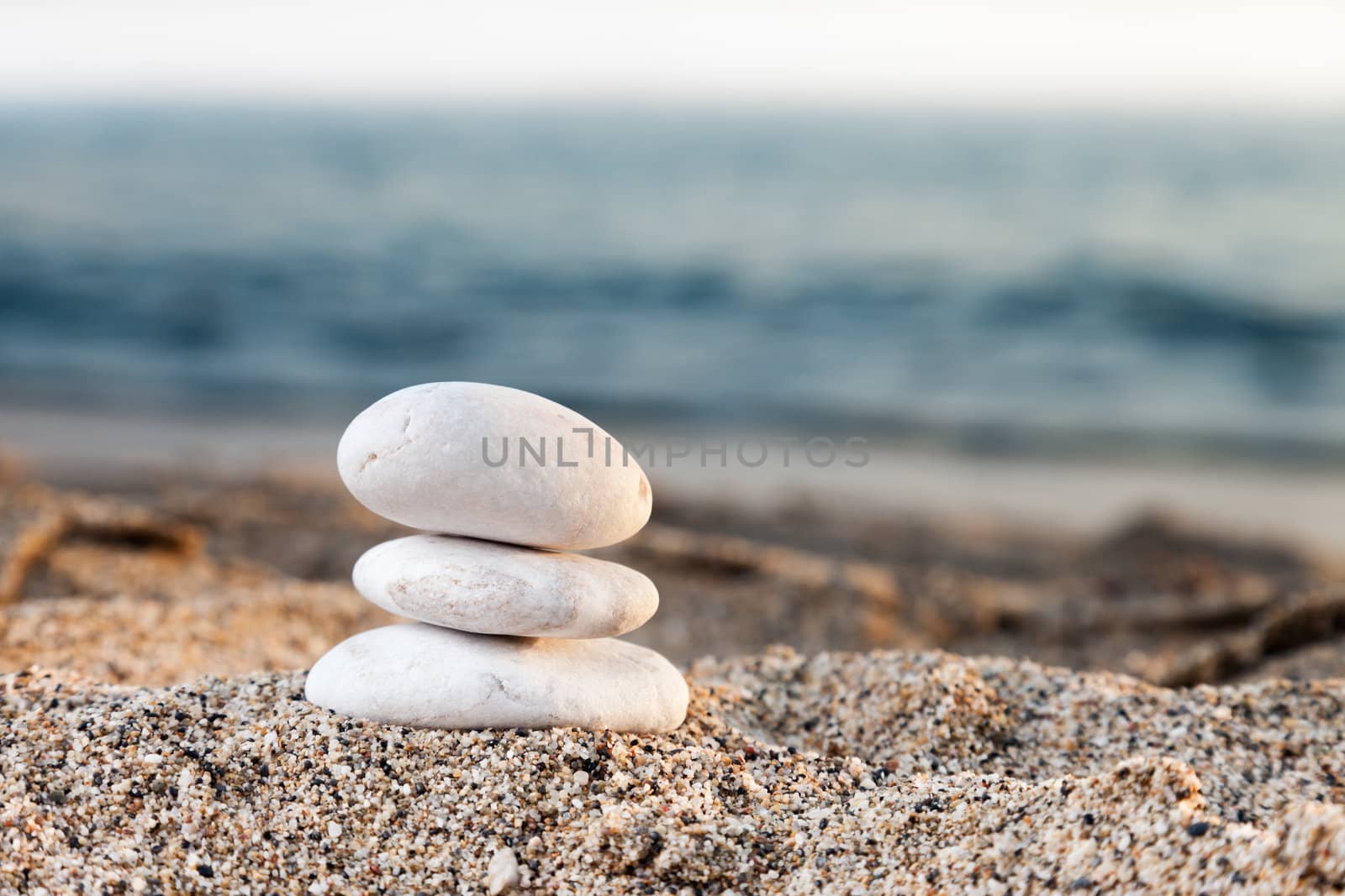 Stability and harmony - stack or pile of balancing rock stones on summer vacations sea sun beach