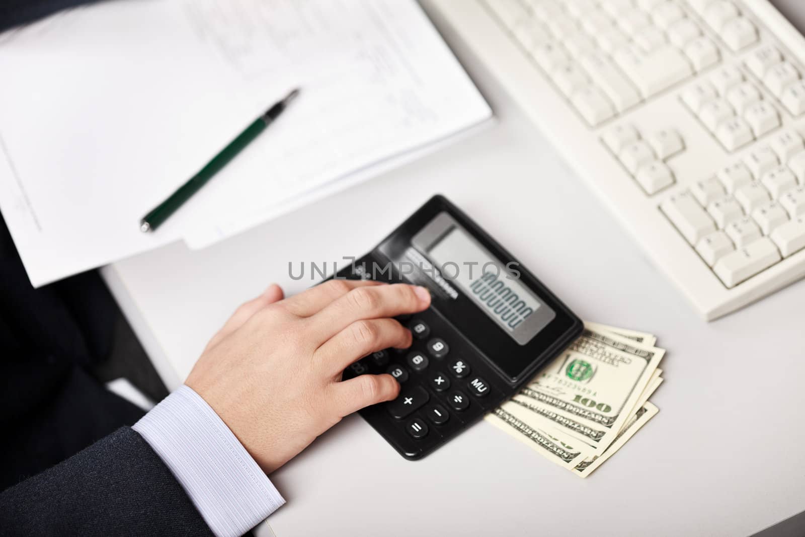 Working business man hand counting or calculating dollar currency at office workplace