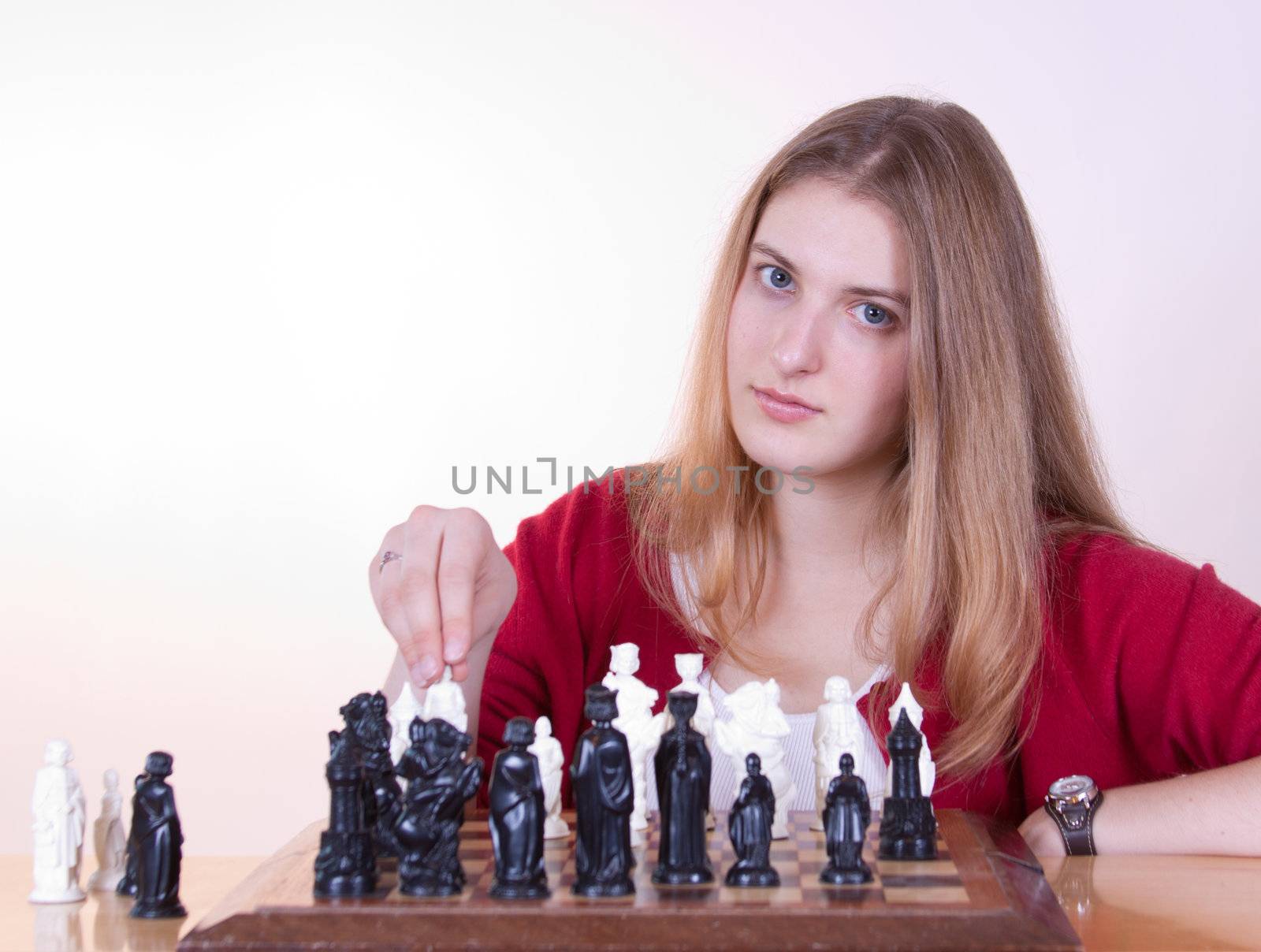 Pretty woman in red playing chess.