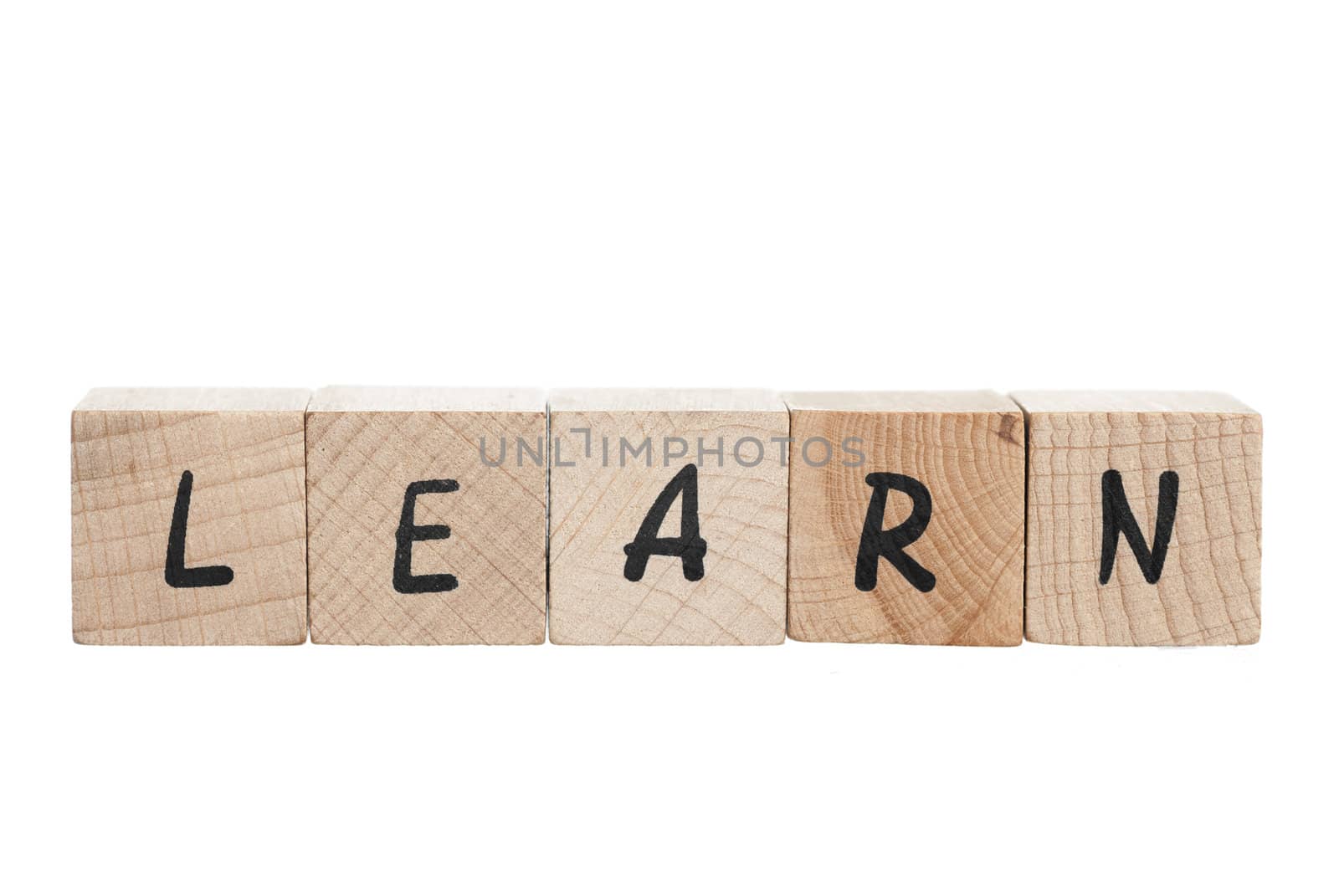 Learn spelled out with wooden blocks. White background.