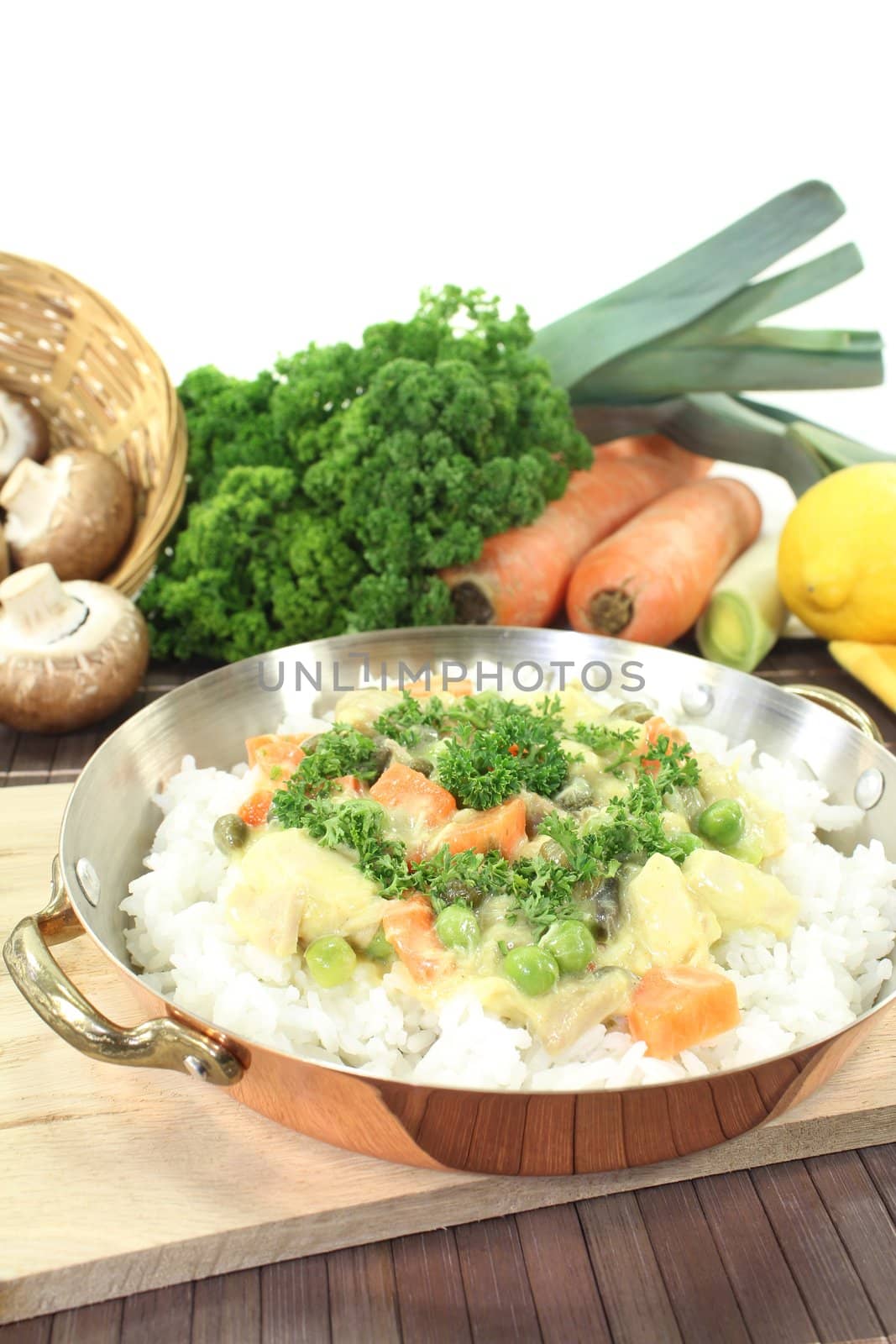 chicken frikassee with rice, carrots, capers and parsley in a pan