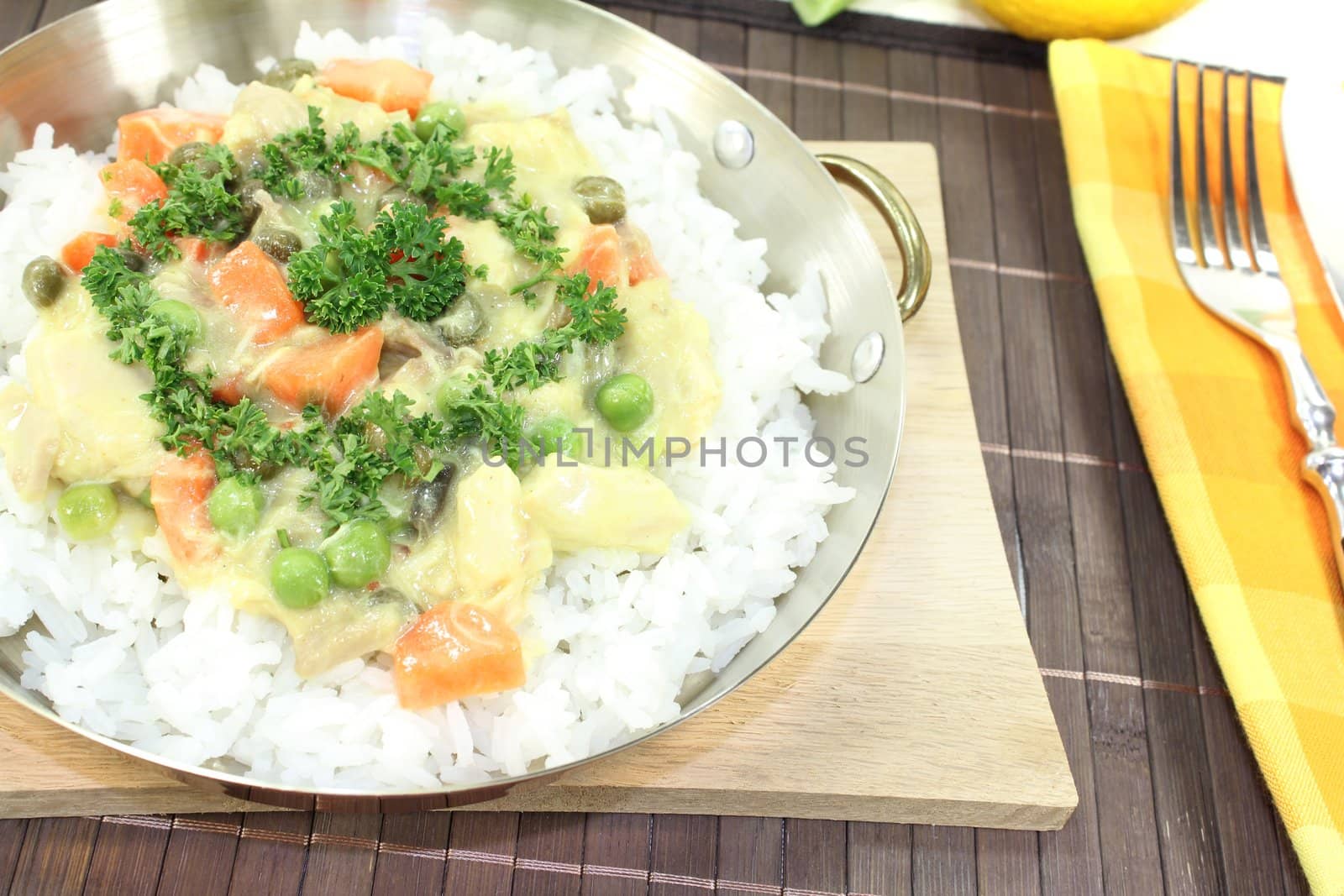 chicken frikassee with rice, peas, leeks and parsley in a pan