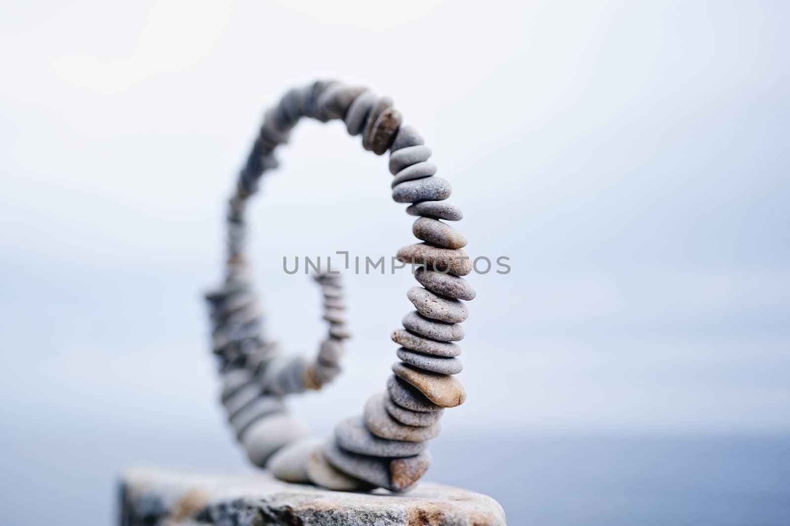 White spiral of pebbles on the boulder at the sea
