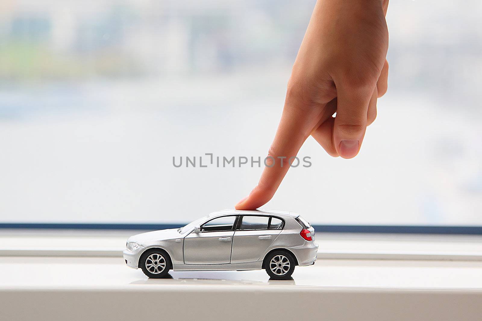 The finger of the businessman moves the toy car