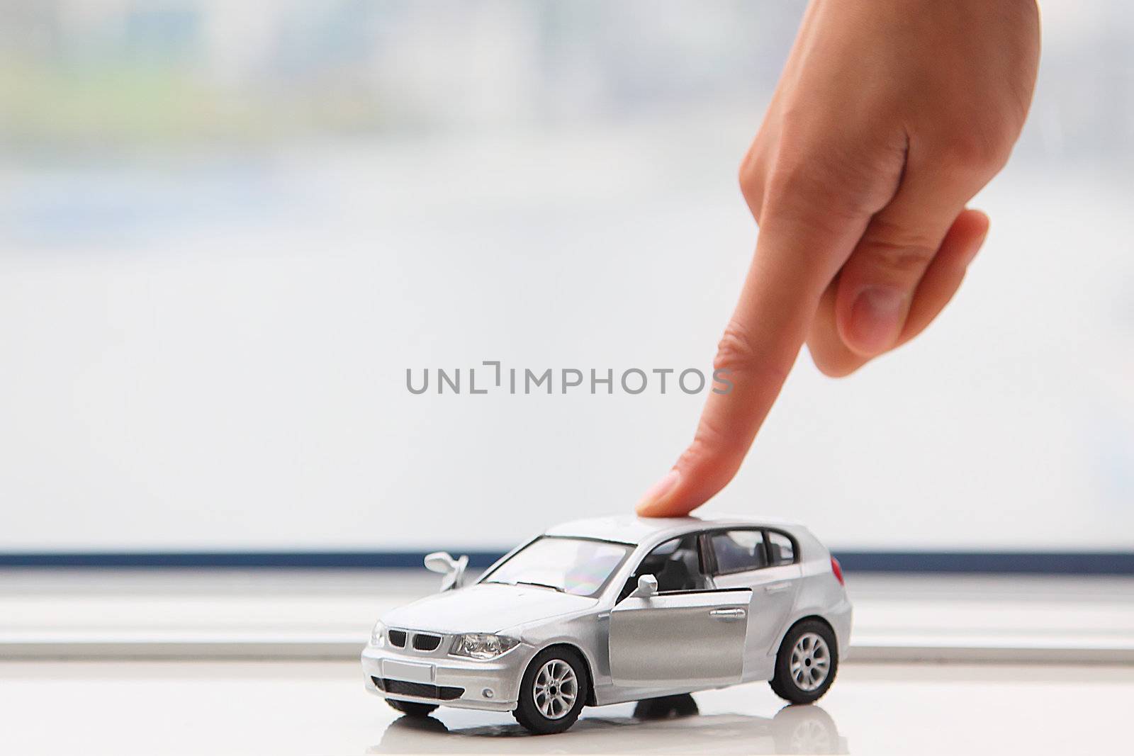 The finger of the businessman moves the toy car