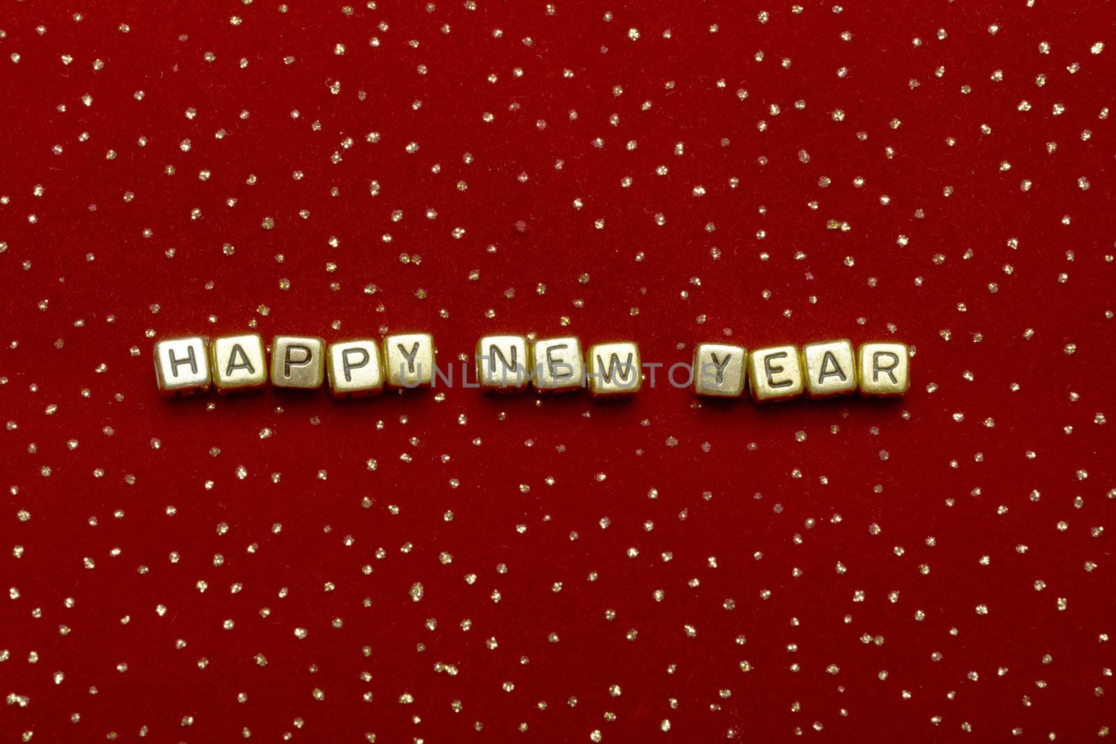photo of phrase "happy new year" of beads on a red velvet with sequins